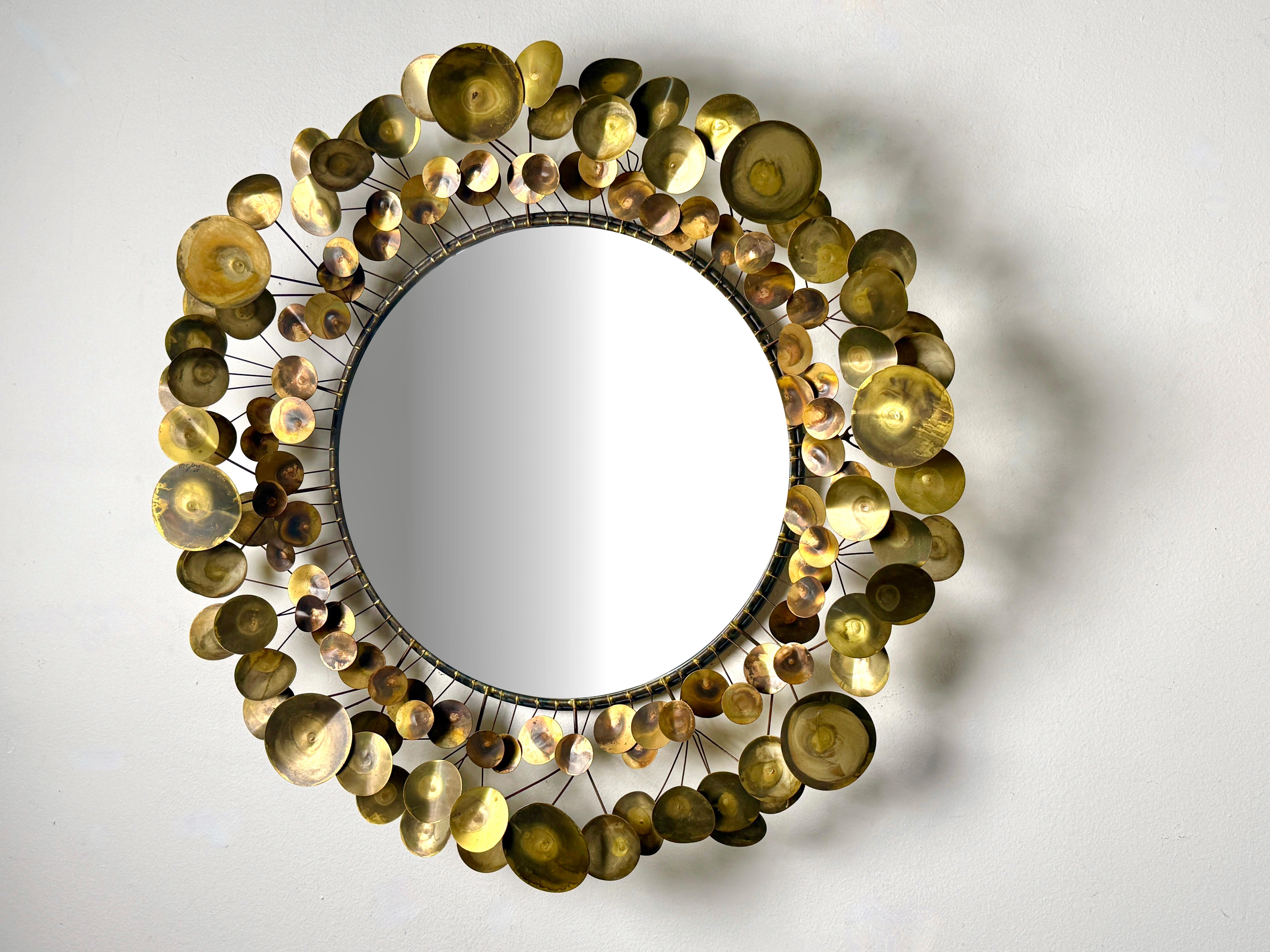 Un primo specchio da parete Raindrops in ottone di Curtis Jere per Artisan House 
Firmato e datato 1968

Specchio centrale rotondo incorniciato da elementi a disco patinati multidimensionali 
Toni metallici misti con un'età e una patina