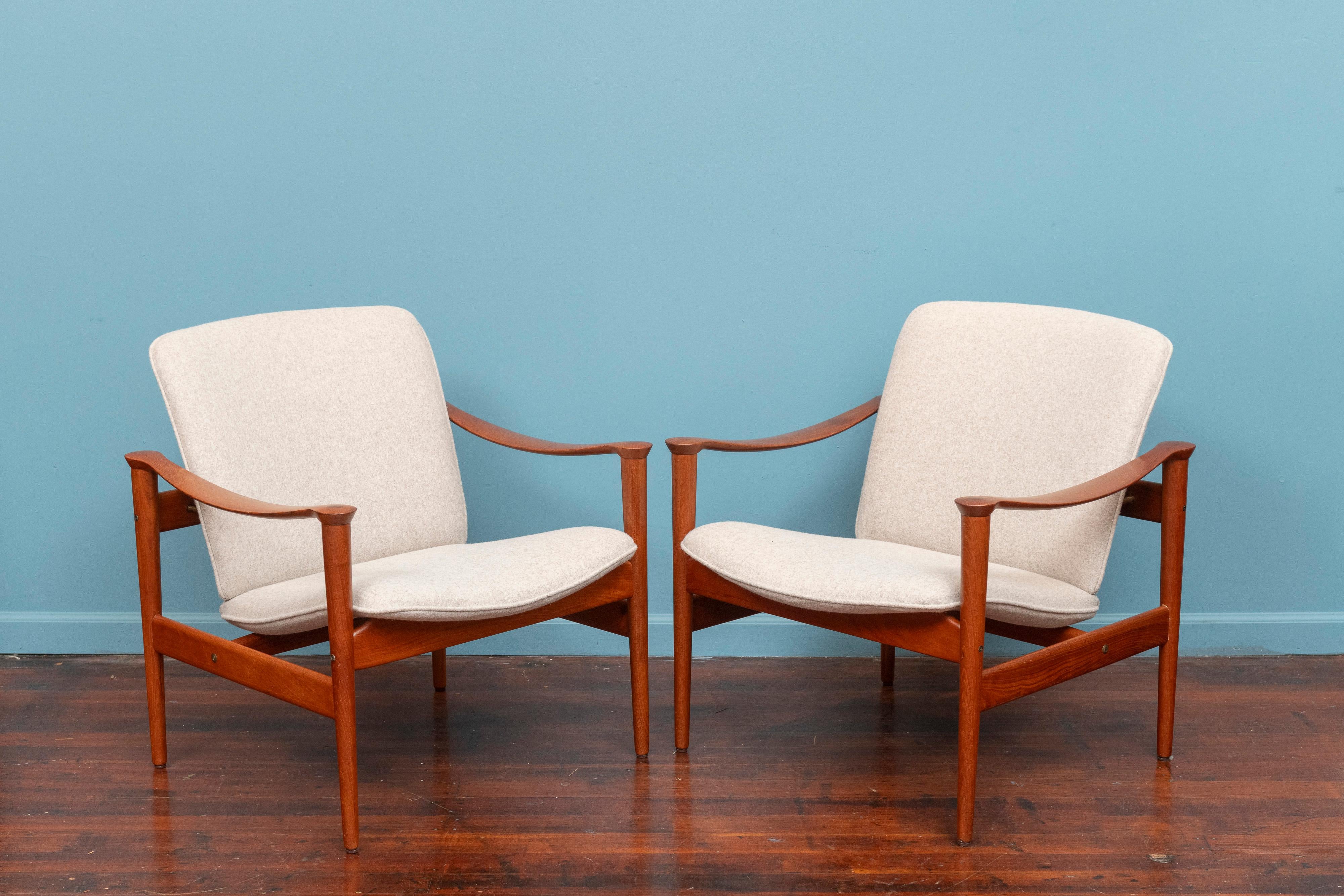 Original vintage pair of Fredrik A. Kayser Model 711 lounge chairs. Sophisticated sculpted teak frames with a minamalist aesthetic, extremely comfortable and relaxing sit. Newly refinished teak frames reupholstered in a latte colored wool felt. Rare
