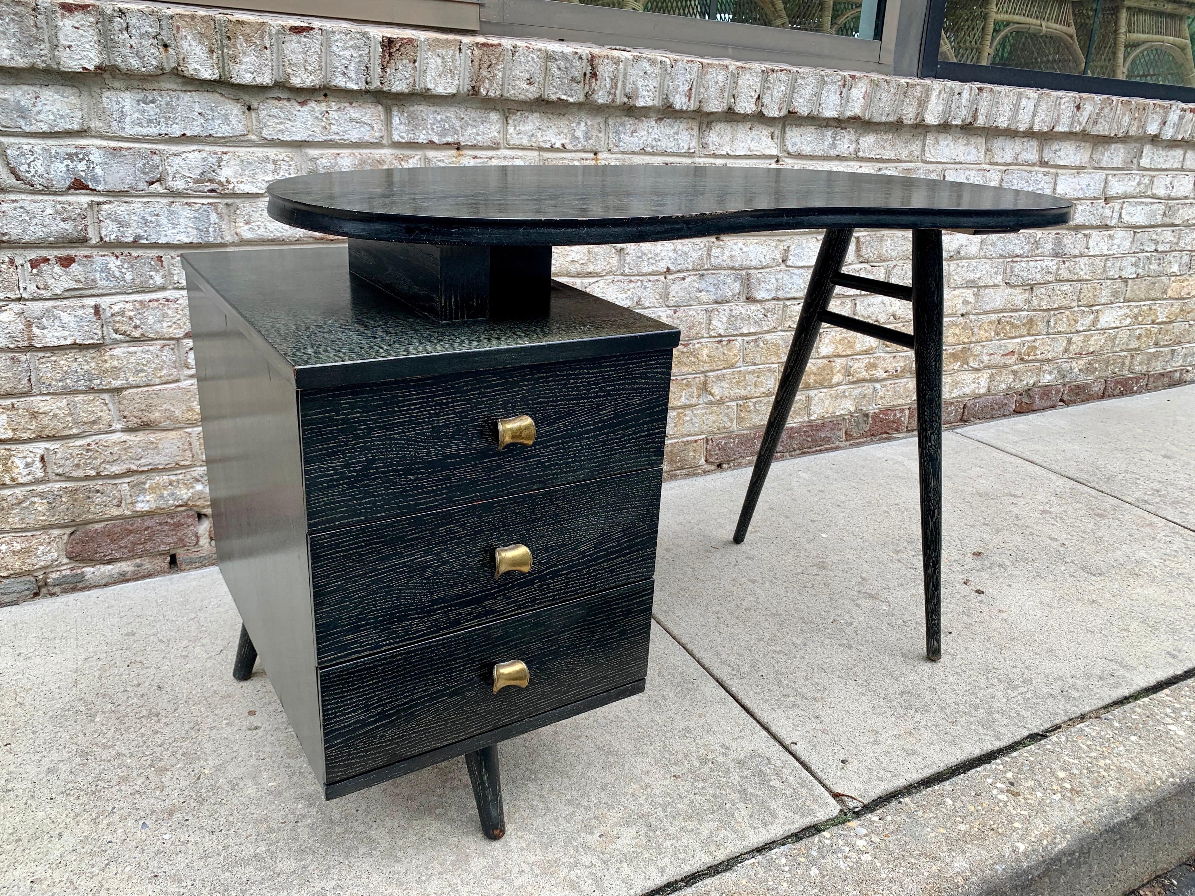 Extremely rare from the American Art Deco era. This kidney shaped desk in black cerused oak (original finish) with tree drawers and turned legs, in as found condition is a truly a unique piece.