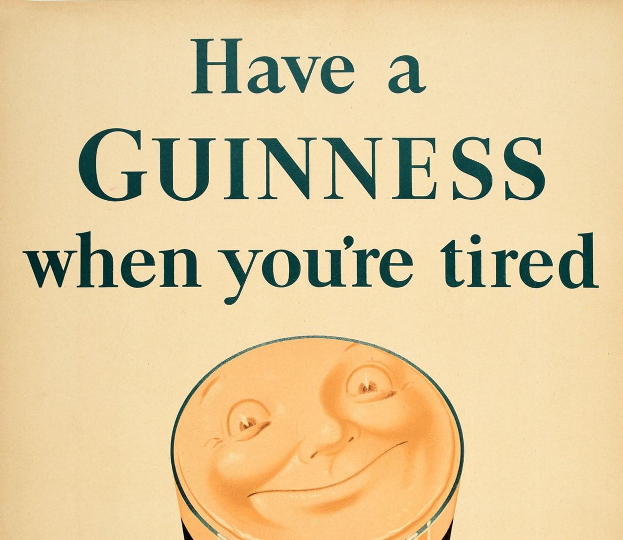Original vintage advertising poster for the iconic drink Guinness Irish stout beer - Have a Guinness when you're tired - featuring a pint glass of Guinness relaxing on a comfortable red armchair with a face smiling out from the foam and the text