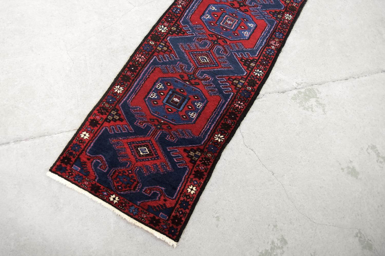 Questo tappeto orientale Hamadan tessuto a mano è stato realizzato in Iran negli anni '60 per Ikea. Tessuto in modo tradizionale, piatto e tinto nei toni del rosso rustico e del blu indaco. Il tappeto viene tessuto nei dintorni di Hamadan, nella