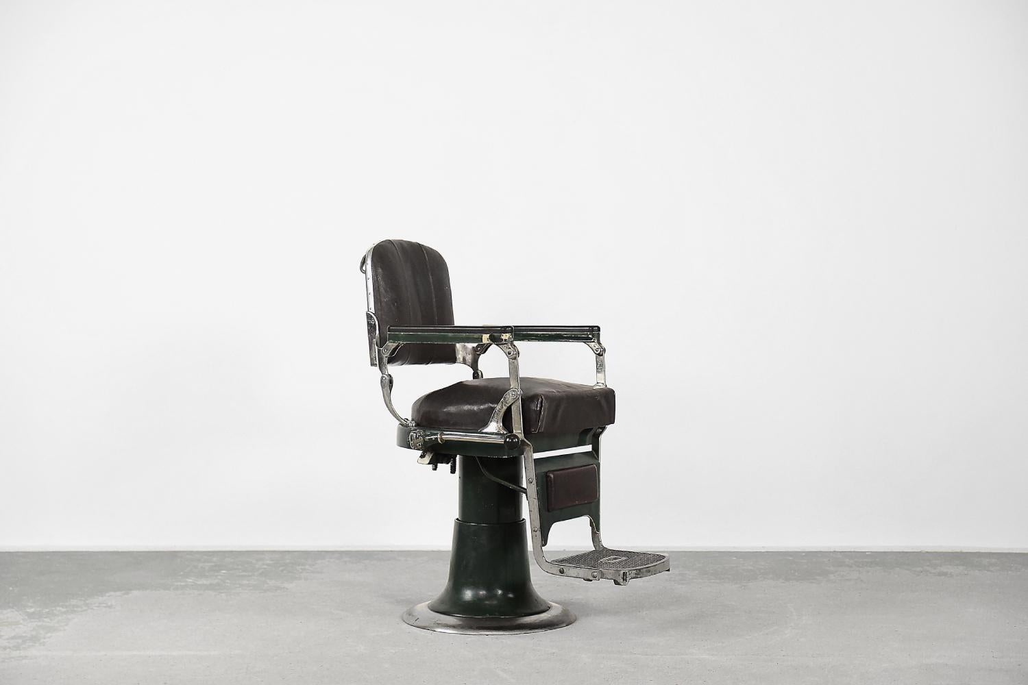 This antique barber chair was manufactured by the Swedish manufacture NIKE in 1927. The seat is swiveling and is raised with a double clutch and lowered with an oil level control. It uses hydraulic pressure to adjust the height of the mechanism. All