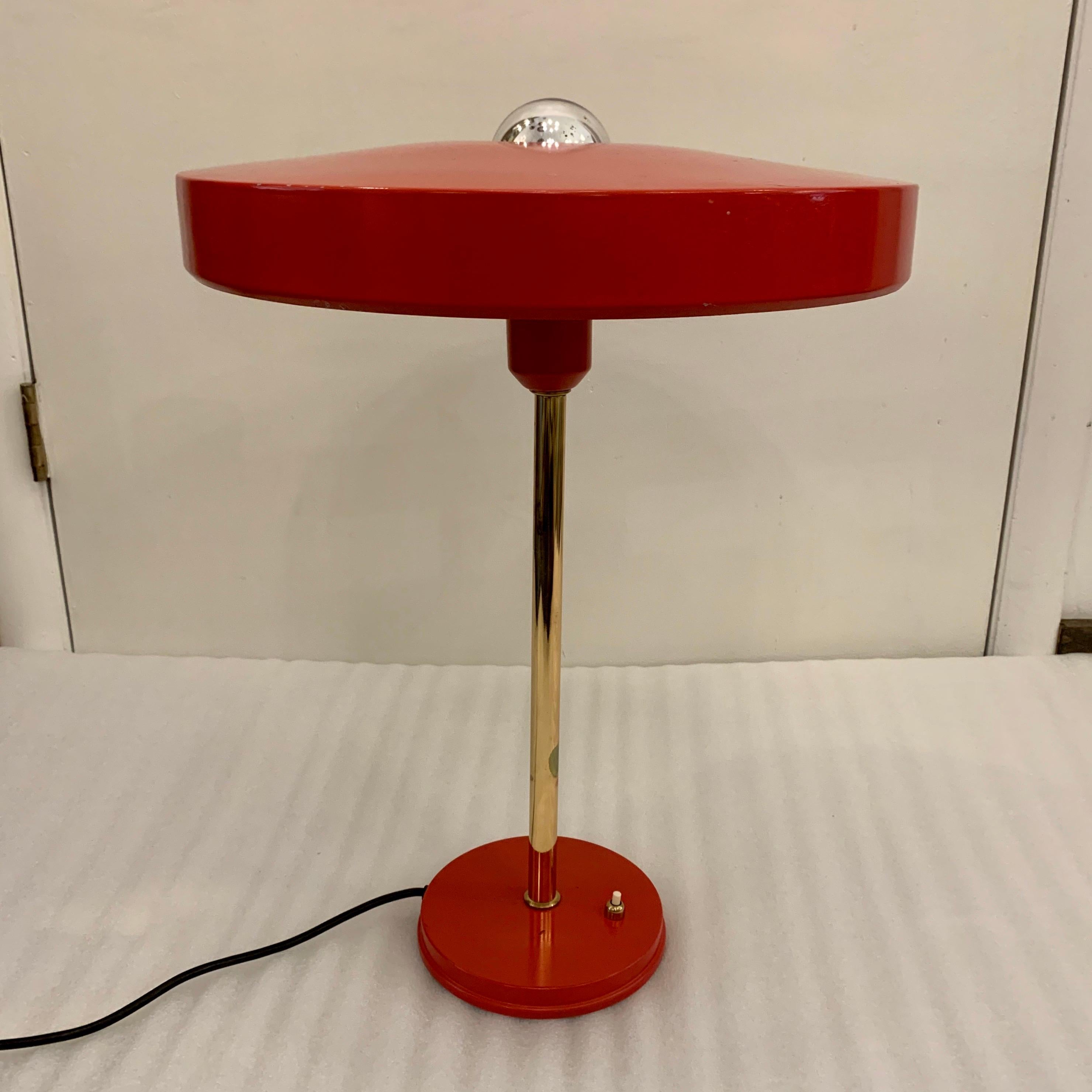 ALL original Louis Christiaan Kalff for Philips red table lamp, 1950s. Featuring round red enameled shade, brass stem and round 6 inch diameter base with original base switch. Shown with mercury bulb and Stamped by famed Dutch manufacturer, Philips.