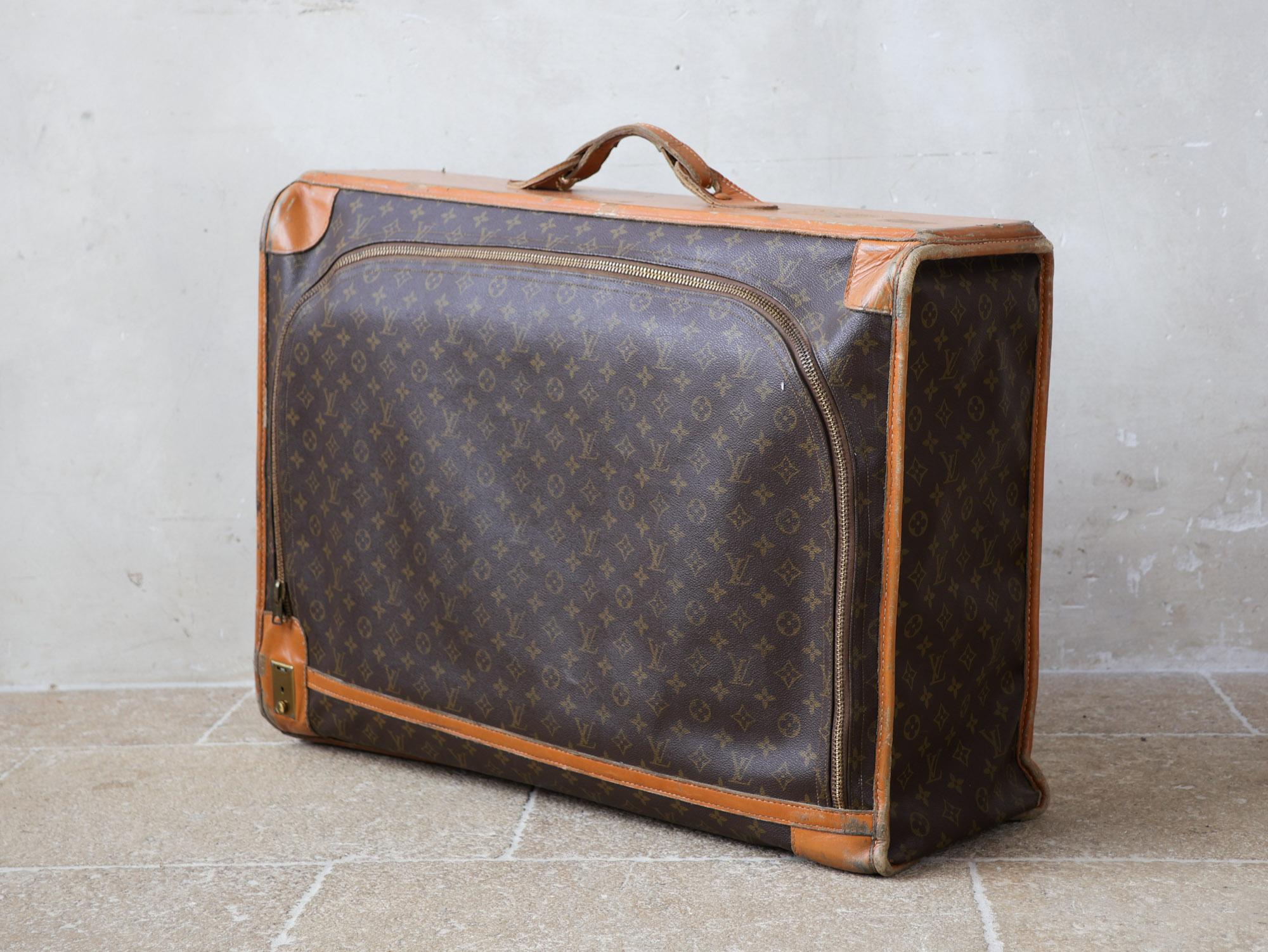 Original vintage Louis Vuitton suitcase, from the 1970s. It has the initials VP. This large soft travel bag is made of leather and canvas and has a zipper at the front. With its signature Louis Vuitton monogram print and Vachetta leather accents,