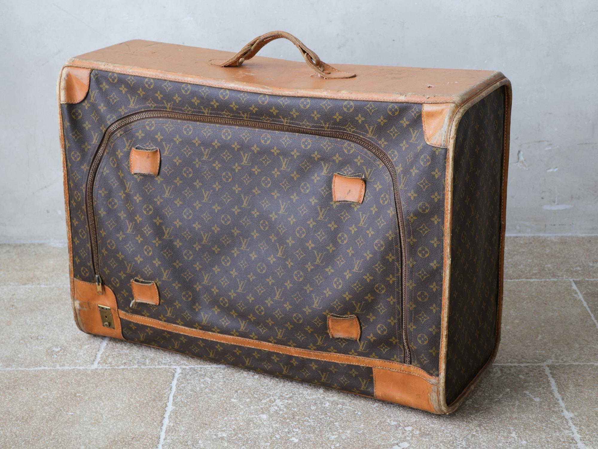 Original vintage Louis Vuitton suitcase, from the 1970s. It has the initials VP. This large soft travel bag is made of leather and canvas and has a zipper at the front. With its signature Louis Vuitton monogram print and Vachetta leather accents,