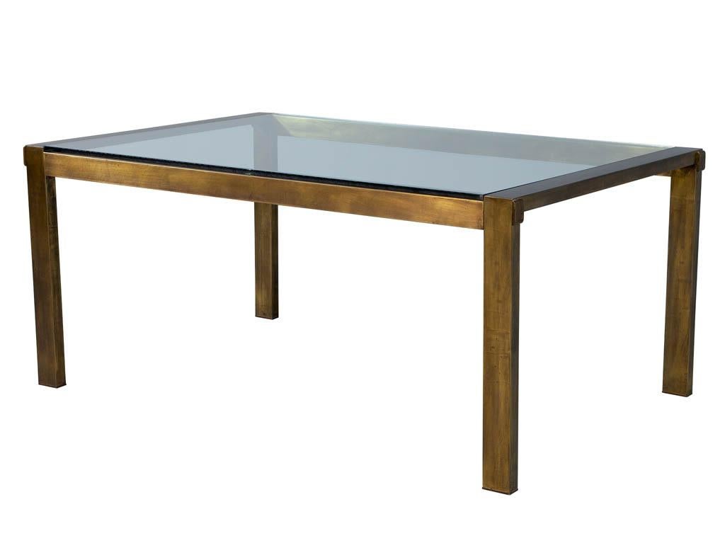 Original vintage Mastercraft aged brass dining table. Rich patinated finish with original glass top and glass pullout extensions. Includes wooden crate for leaf storage. Original glass does have minor wear consistent with age and use. 

Table