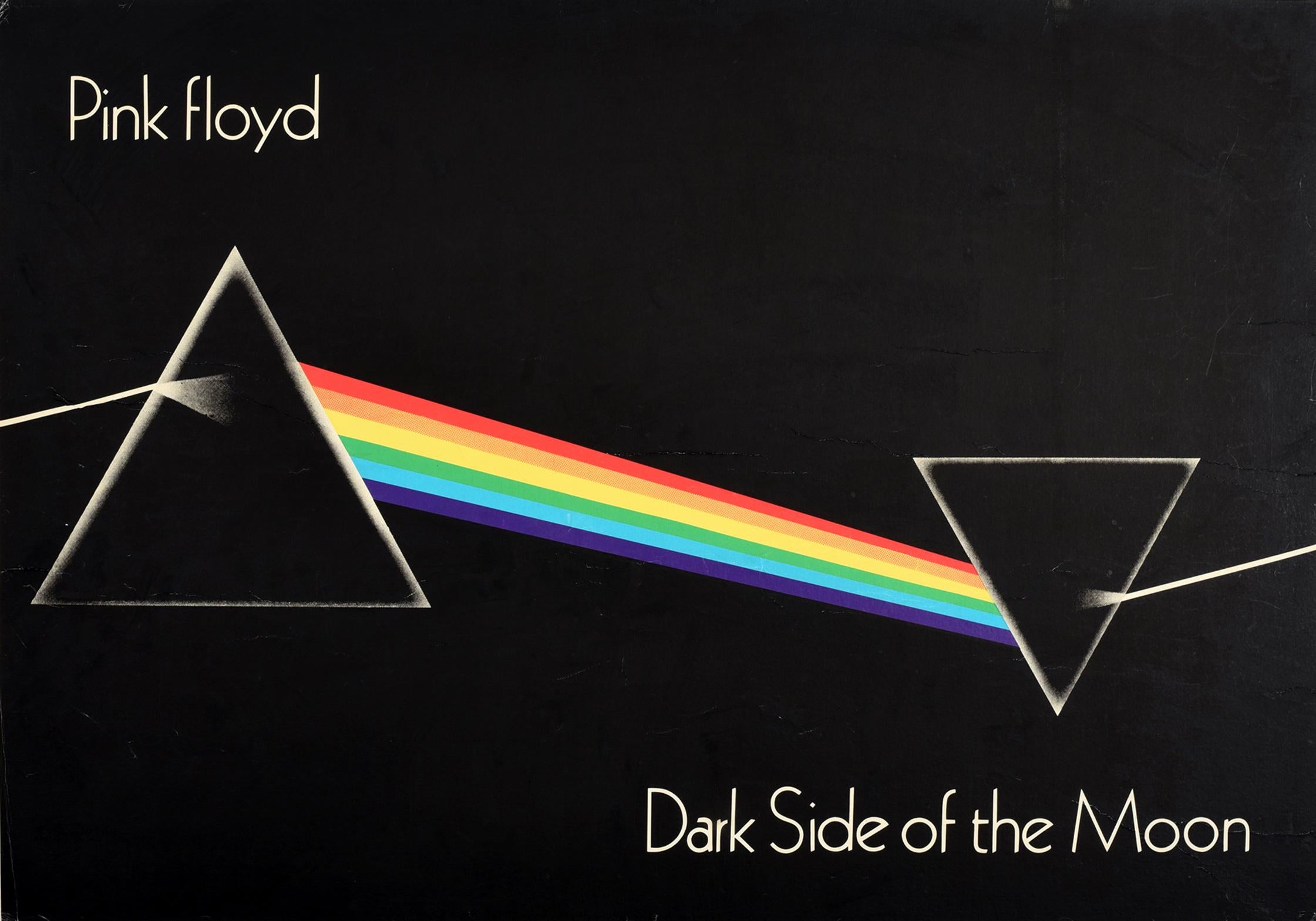 Original vintage music poster for the Pink Floyd album The Dark Side of the Moon featuring a variation of the iconic album cover art depicting a simple and bold design of light refracting from a triangular dispersive glass prism forming a rainbow as