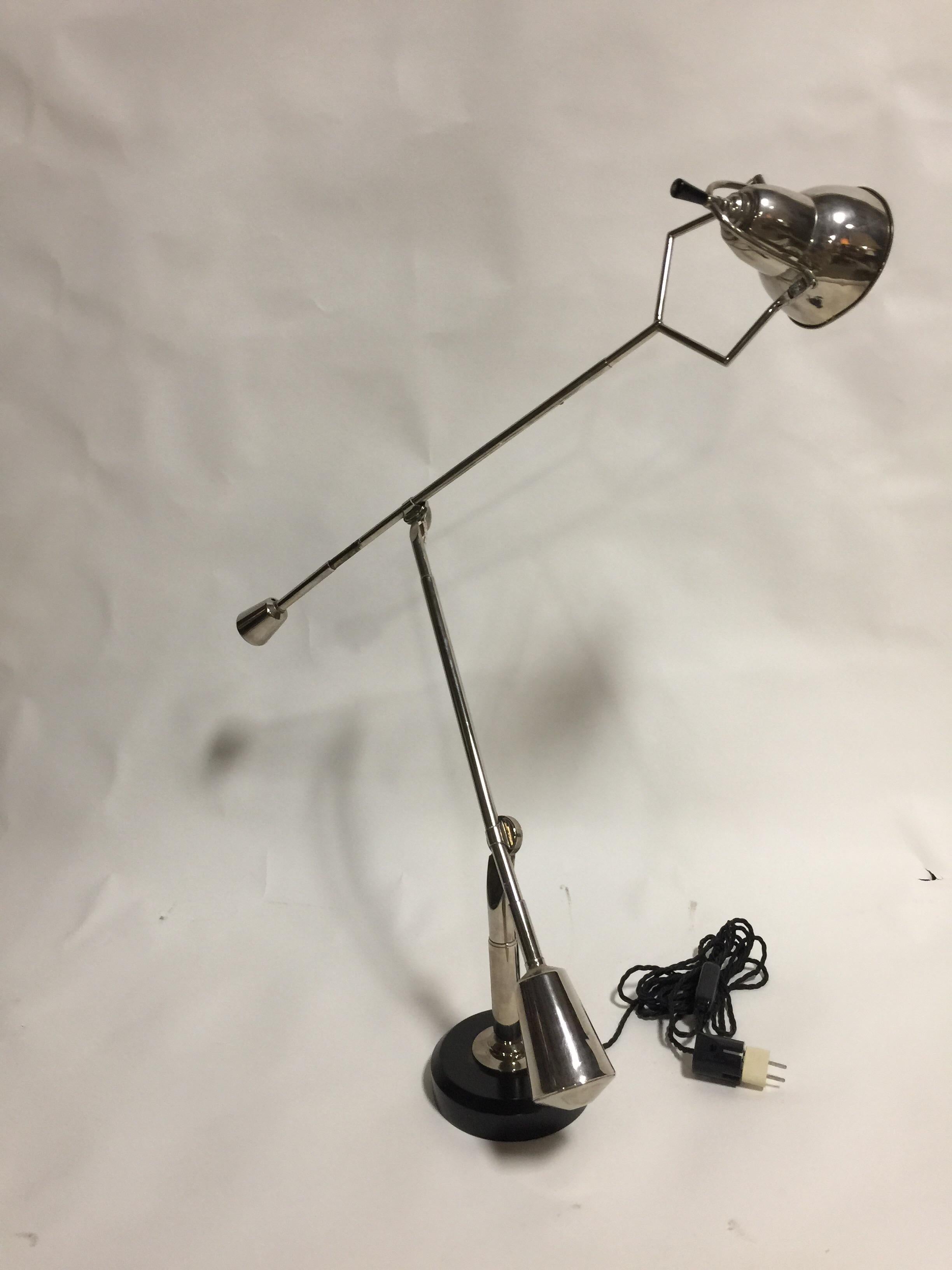An early desk lamp handmade by Édouard-Wilfred Buquet. France, 1927. Nickel-plated brass arms with an aluminum shade, resting on a round ebonized and lacquered wood base.

Features original European silk-covered cord, wiring and plug; includes plug