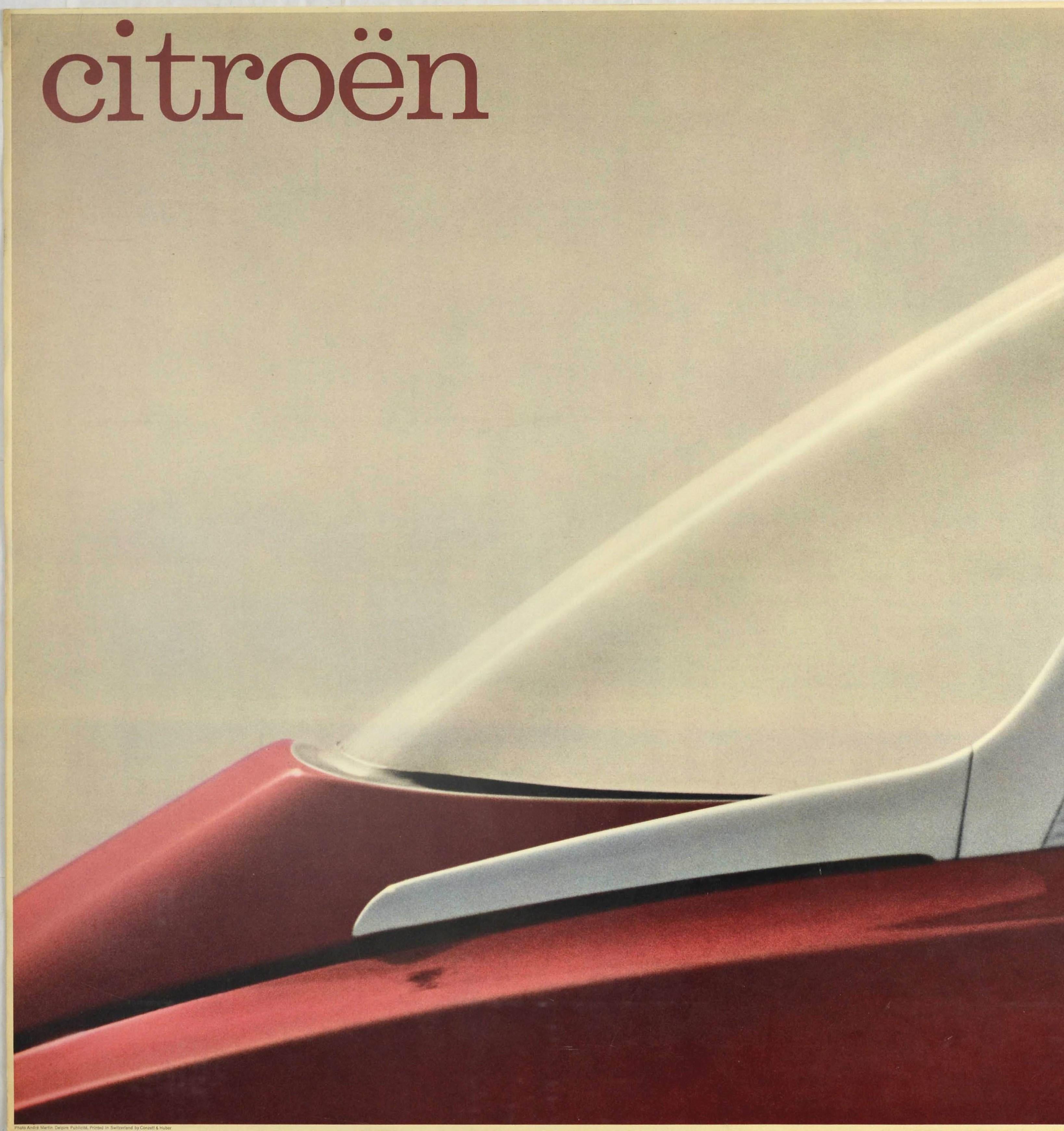 Original vintage car advertising poster issued by the French automobile manufacturer Citroen (founded 1919) featuring a great minimalist design showing a partial photo of the rear windshield of a red and silver 1960 Citroen DS car with the word