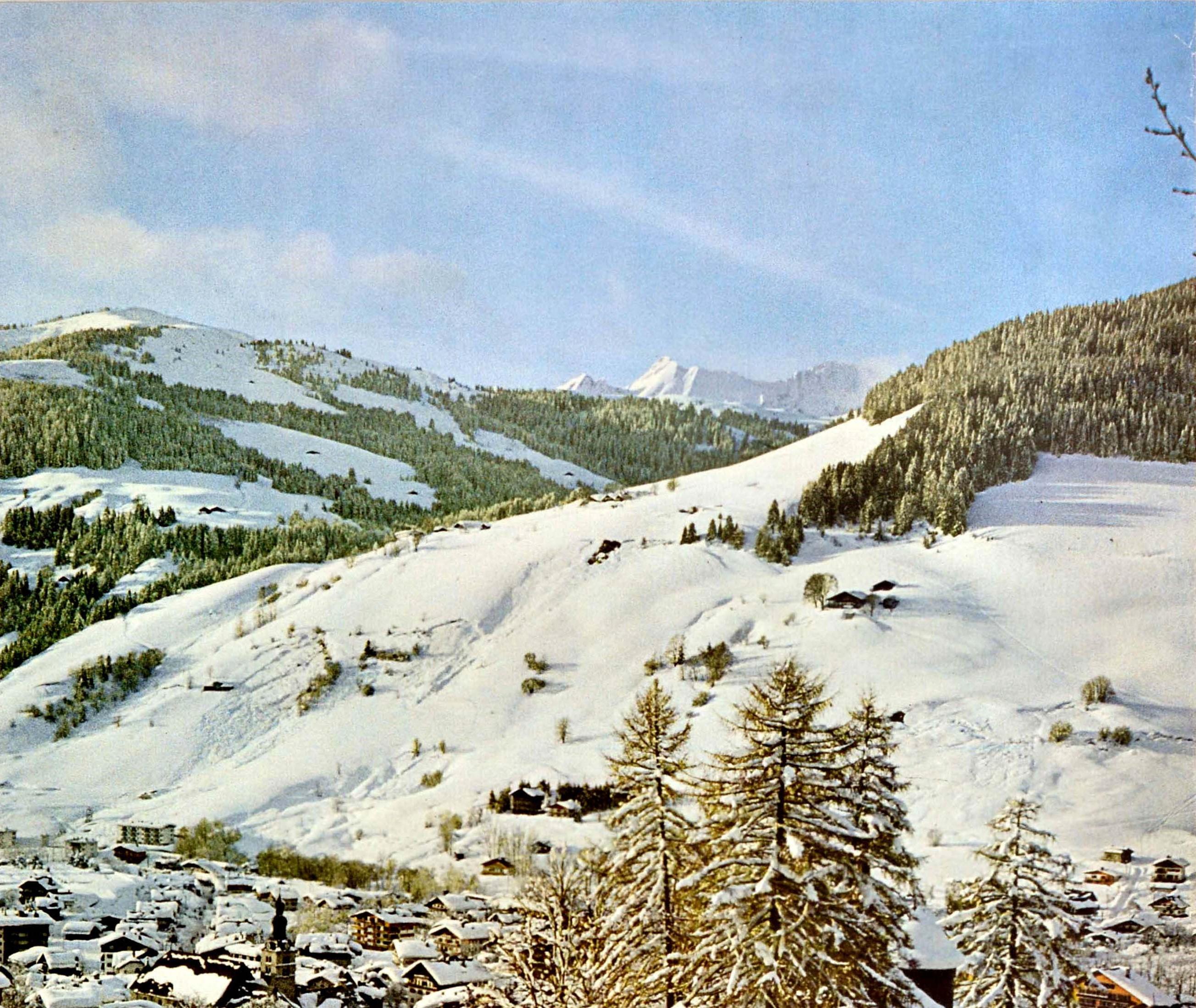 Original-Reiseplakat von Megeve in Frankreich mit einer Fotografie des Dorfes im Winter mit schneebedeckten Chalets und Menschen, die einen Hügel hinuntergehen, mit den verschneiten Bäumen und Berggipfeln am Horizont. Das beliebte Skidorf Megeve