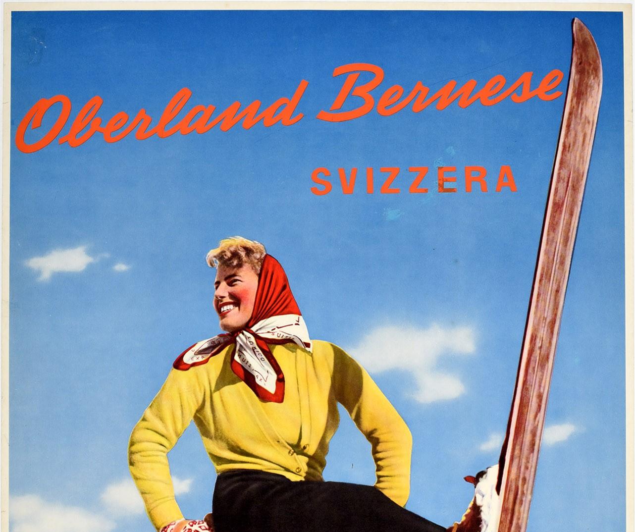 Original vintage ski travel poster - Oberland Bernese Svizzera - featuring a colourful image of a smiling lady in a headscarf leaning back on her poles and holding one ski up in the snow with trees in the background and the stylised lettering across