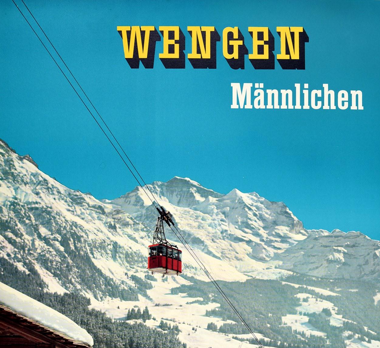 Original vintage winter sport travel poster for Mannlichen Wengen in Switzerland featuring a colorful photograph of people standing in the deep snow and sitting next to their skis leaning against a wooden chalet below a red cable car ski lift