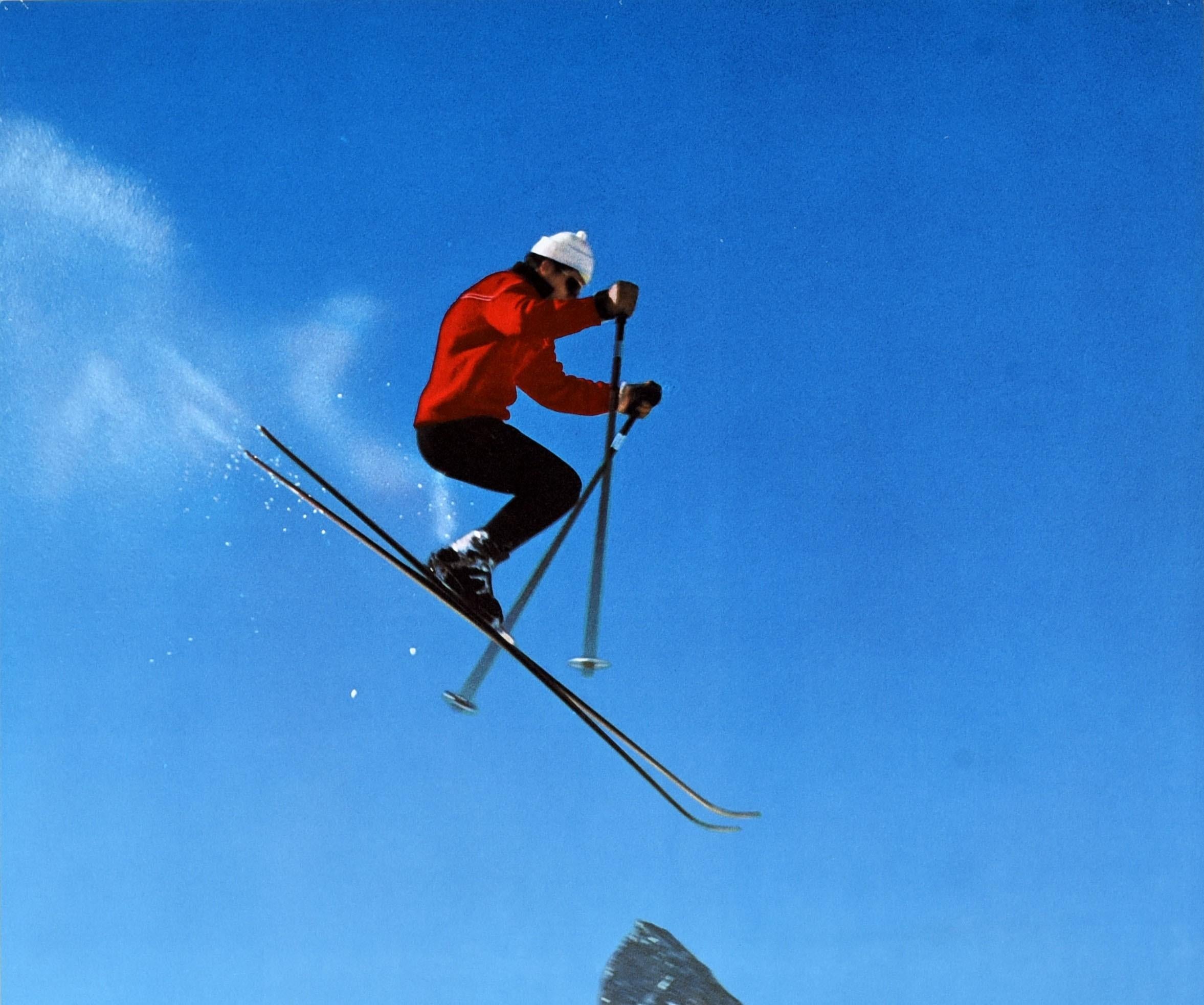 Original vintage skiing and winter sport travel poster for Zermatt Switzerland Schweiz Suisse featuring a dynamic photo by Alfred Perren-Barberini of a skier wearing a red ski jacket and white hat jumping in front of the iconic Matterhorn mountain
