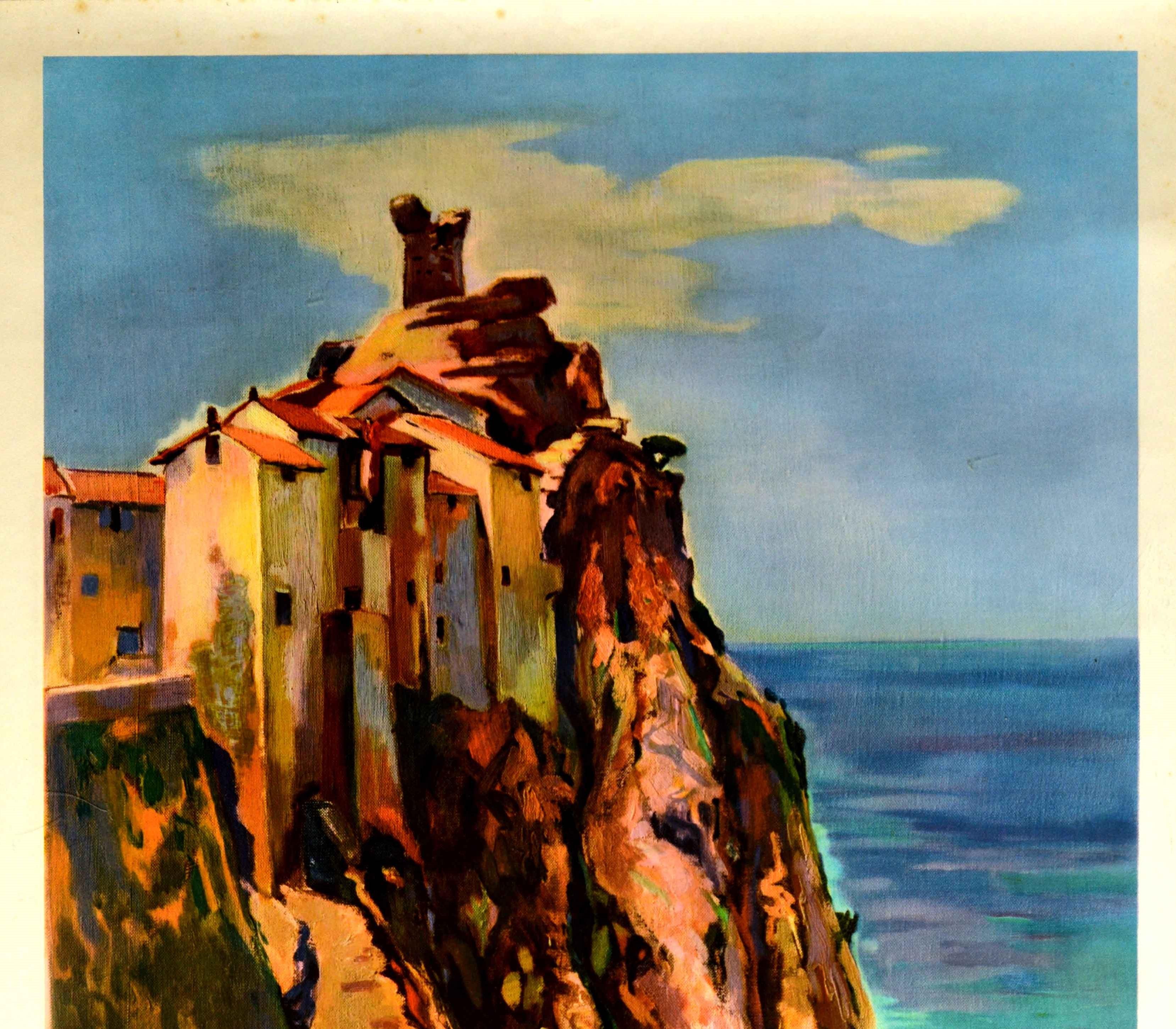 Original vintage travel poster for the Mediterranean island of Corsica in France issued by French Railways featuring a colourful image of a lady walking on a stone path in front of buildings built on the rocky cliff over the Mediterranean Sea with