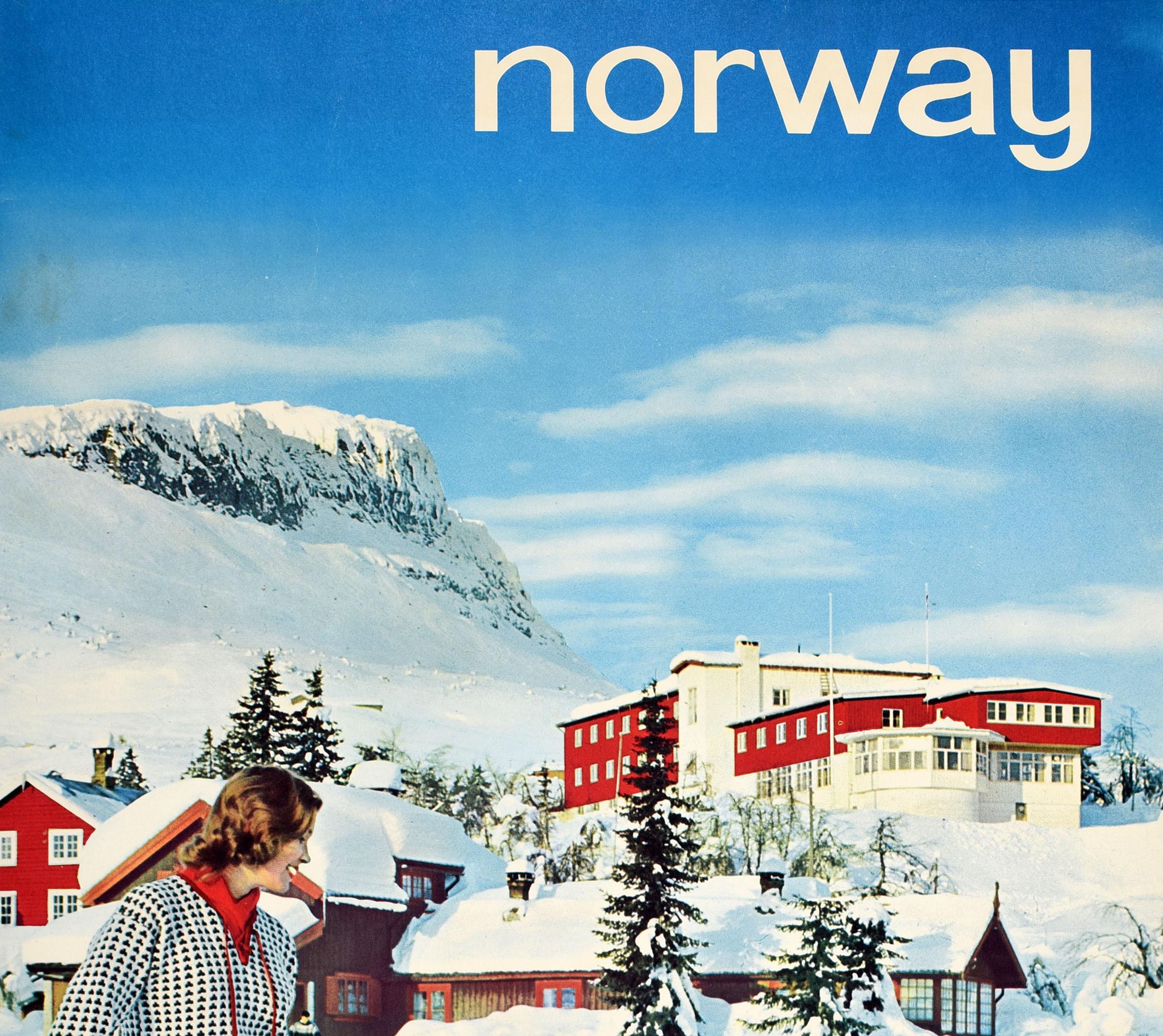 Original vintage ski and winter sport travel poster for Norway featuring a colour photo by Arne With Normann (1911-1990) of two smiling skiers in patterned jumpers putting on their skis in front of snow topped chalet buildings, trees and mountain in