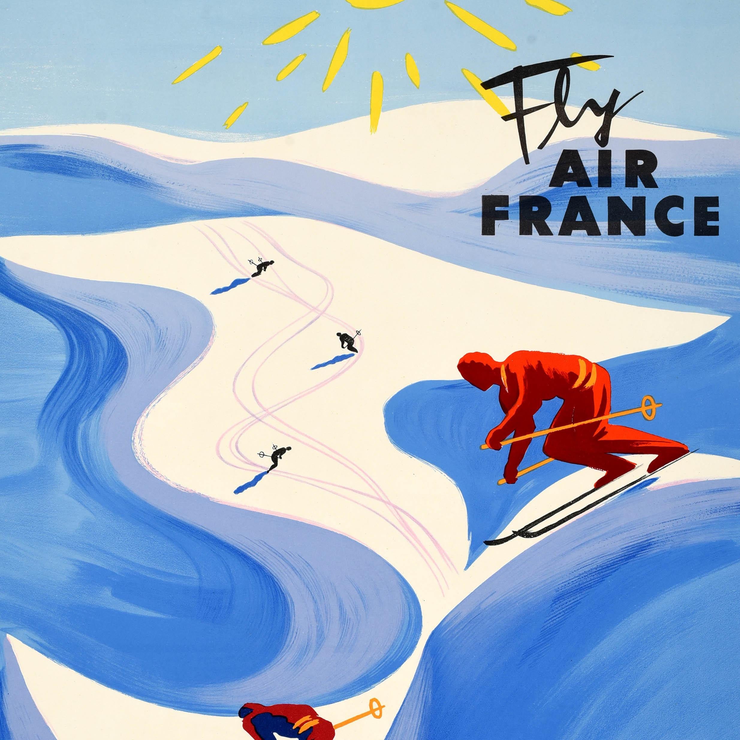 Original vintage ski travel poster - Winter Sports Fly Air France - featuring colourful artwork by the renowned graphic artist Bernard Villemot (1911-1989) depicting skiers skiing down snowy slopes on mountains in shades of white and blue lit up by
