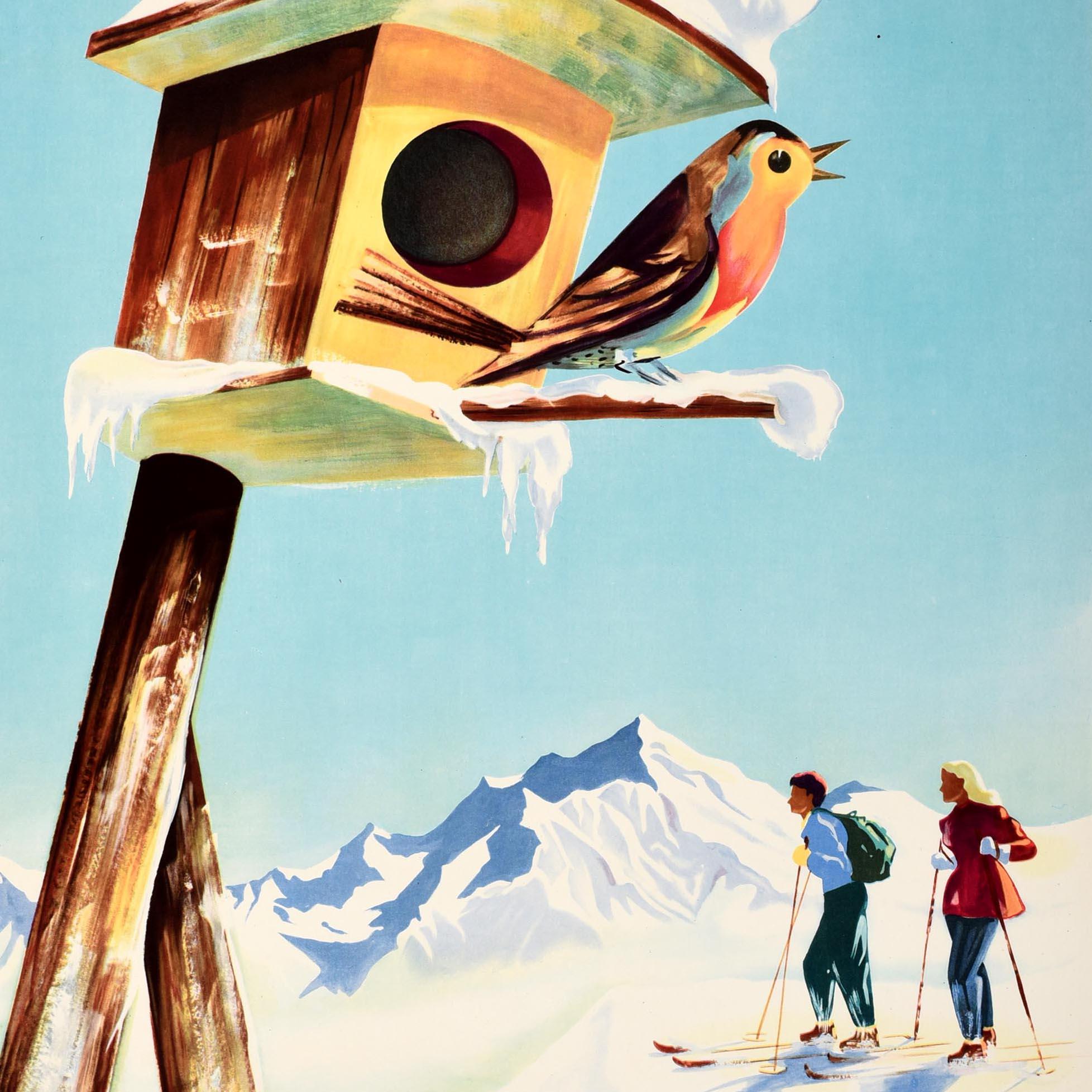Original vintage skiing poster advertising Winter Sports in France / Wintersport in Frankreich - featuring a great design depicting a couple on skis enjoying the view of the snowy mountains below the blue sky background, a robin redbreast bird on a