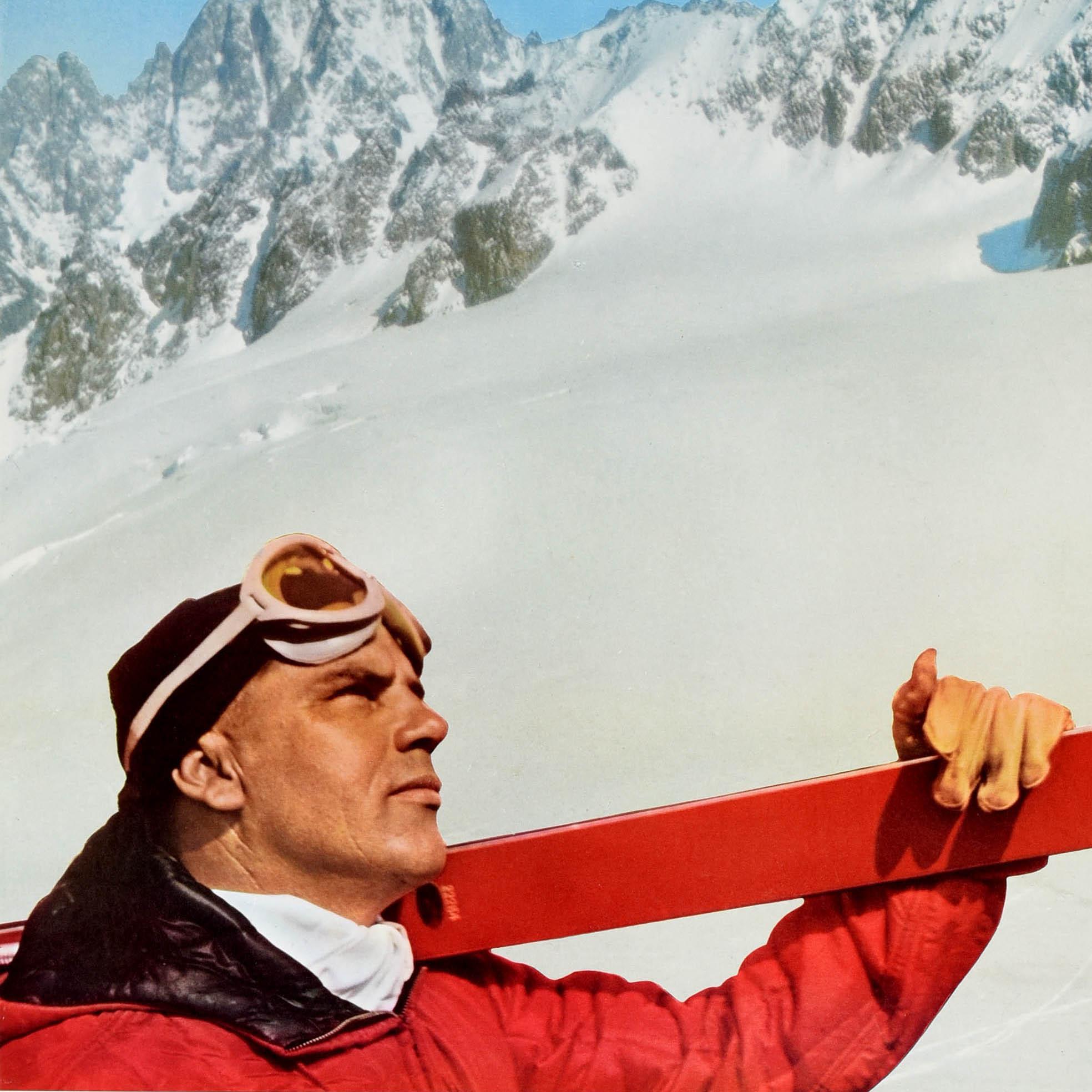 Affiche originale de voyage de ski vintage - Ski Italy on Europe's Most Exciting Mountains Alitalia Airlines - représentant un skieur avec des lunettes de ski sur la tête et tenant une paire de skis rouges sur son épaule, regardant les sommets des