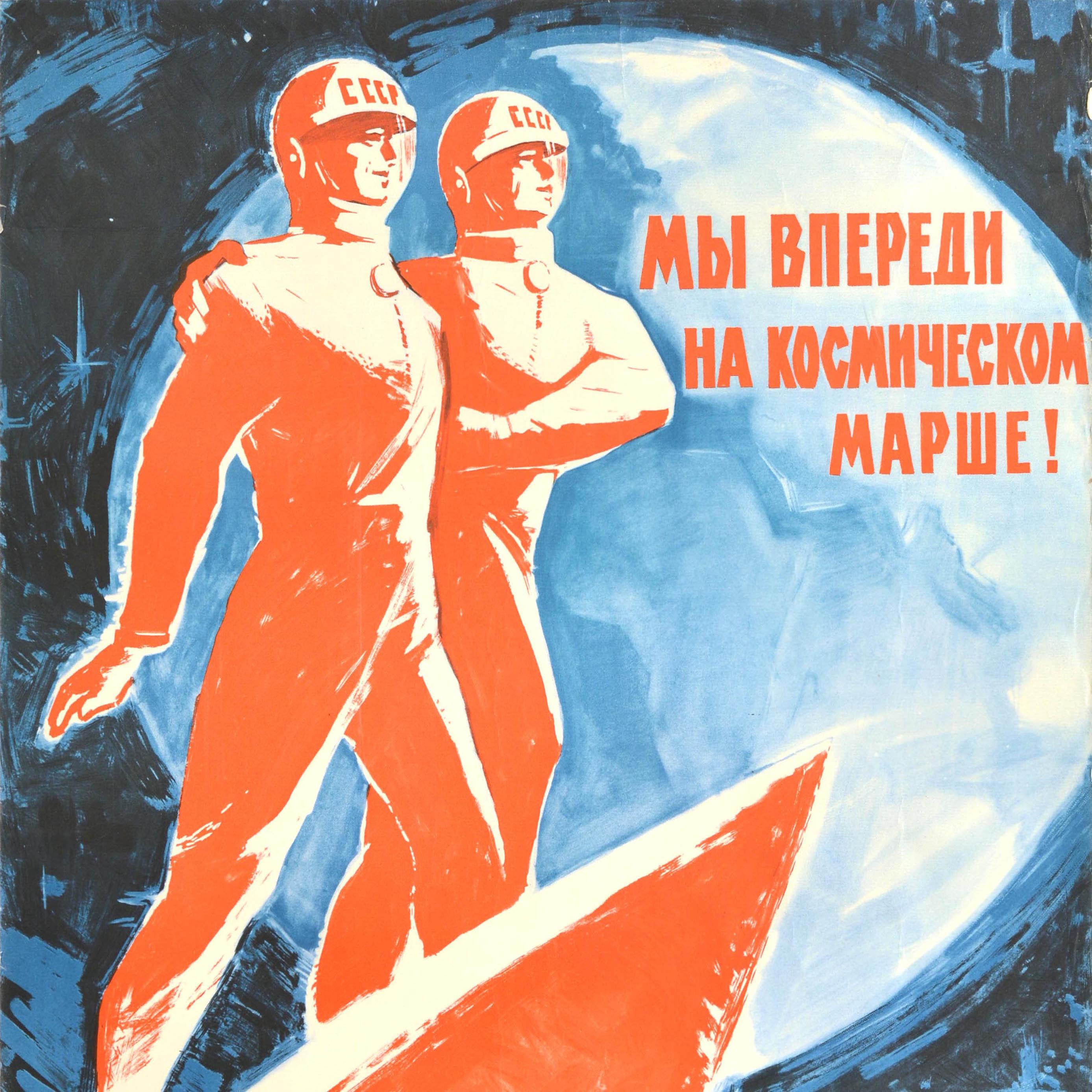 Original vintage Soviet space race propaganda poster - We Are Ahead On The Space March! - featuring a dynamic image of two cosmonauts with CCCP / USSR on their helmets standing on a Voskhod 2 rocket with a planet on a starry sky background, the