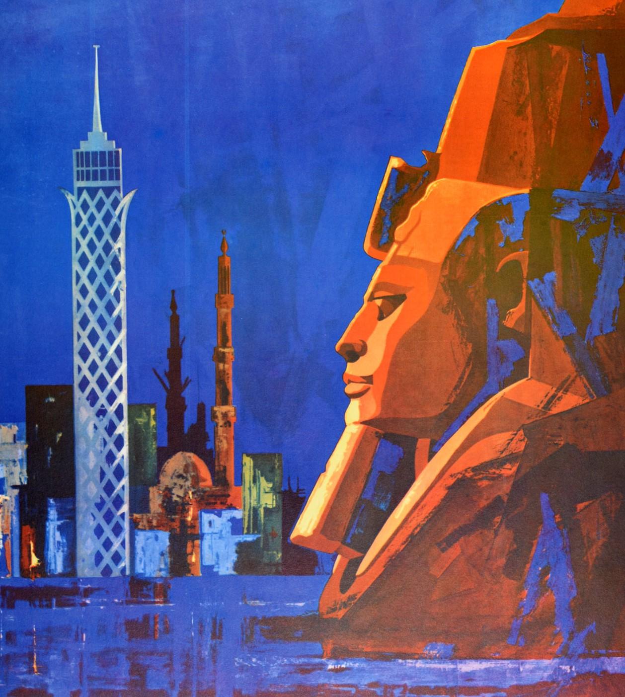 Original vintage travel poster for Egypt UAR (United Arab Republic; 1958-1971) featuring traditional and modern city buildings against the dark blue shaded background with an ancient Sphinx head in the foreground. Excellent condition.