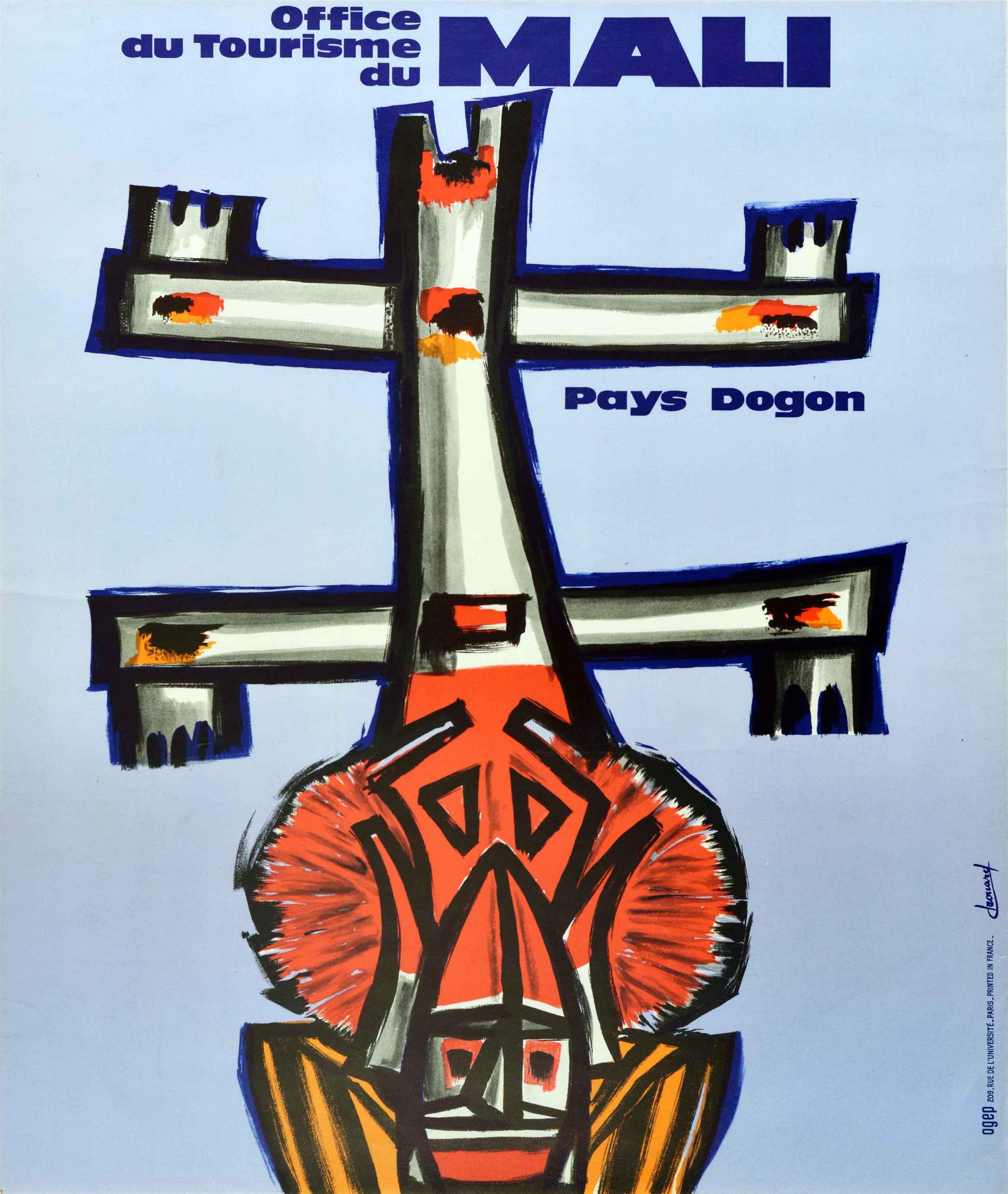 Original vintage travel poster featuring an artsy image of a traditional wooden Dogon mask on a blue background with the bold title lettering above. The Dogon ethnic group live in the central plateau region of Mali in West Africa and are known for