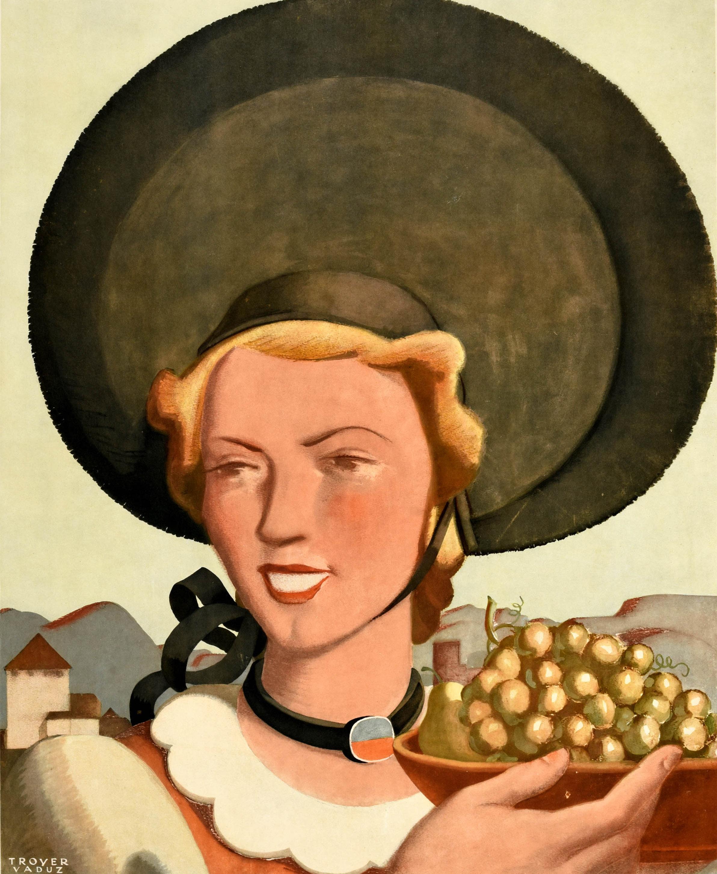 Original vintage travel poster for the Principality of Liechtenstein / Furstentum Liechtenstein featuring artwork by Johannes Troyer (1902-1969) of a smiling lady wearing a large hat and holding up a bowl of grapes in front of an old building and
