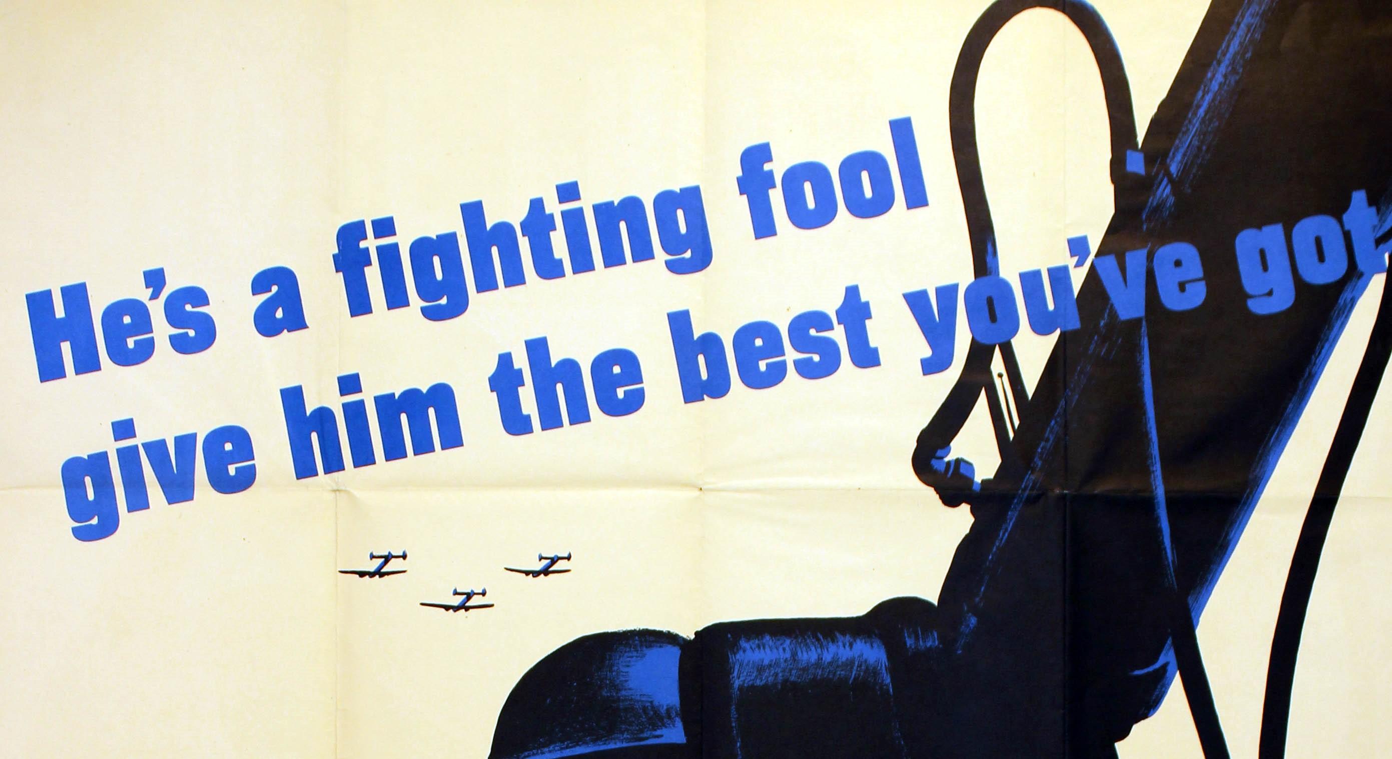 Original vintage World War Two poster: More Production. He's a fighting fool - give him the best you've got. Image of an anti-aircraft gunner in a helmet watching the sky with three airplanes flying overhead. Artwork by Fred Ludekens (1900-1982).