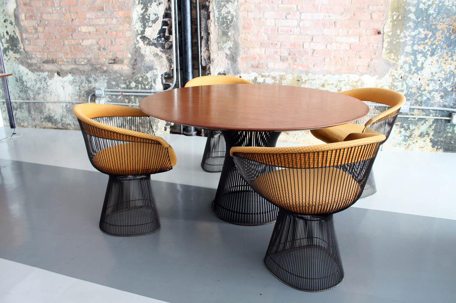 Original dining set by Warren Platner for Knoll. This set is in wonderful original condition. The walnut top of the dining table top is in very fine condition. A Knoll sticker is present to the underside of the table top. The bronze bases are all