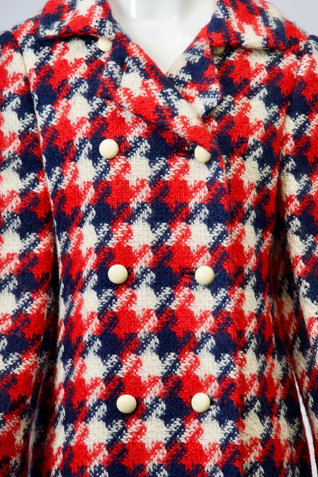 1960s double-breasted coat by one of America's best manufacturers is fashioned of a wide-weave wool in red, white, and blue large-scale herringbone plaid. The coat features a half-belt in back above an inverted pleat, hidden pockets, and ivory toned