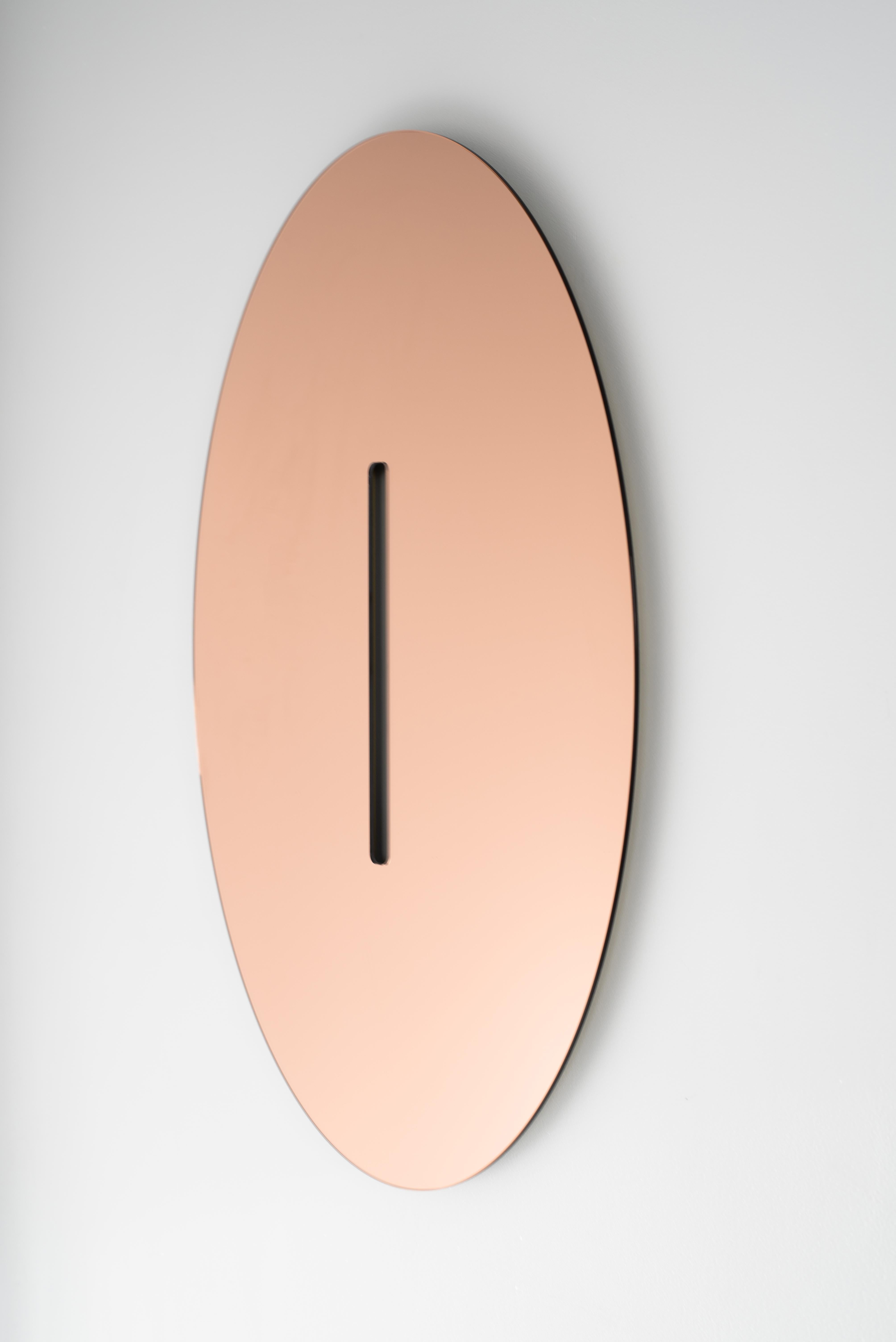 A study in form through mirror, the absence of mirror is the central and subtle focus in this oval shaped piece. Made to order, customization in mirror finish is available. Shown here in Peach Mirror.

Mirror Options -