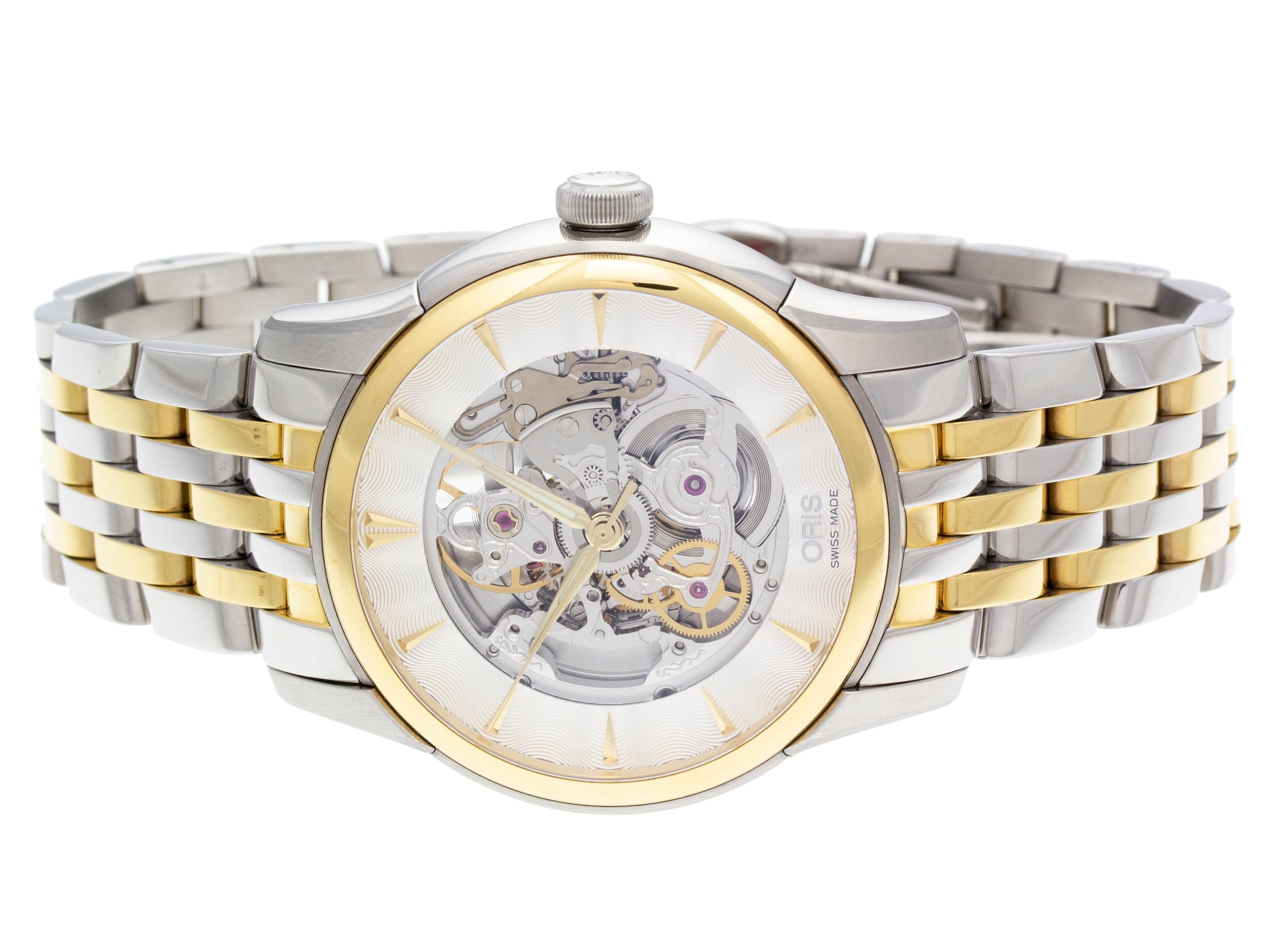 Stainless steel & yellow gold PVD Oris Artelier Skeleton automatic watch with a 40mm case, skeleton dial, and bracelet with folding clasp. Features include hours, minutes, and seconds. Comes with a Deluxe Gift Box and 2 Year Store