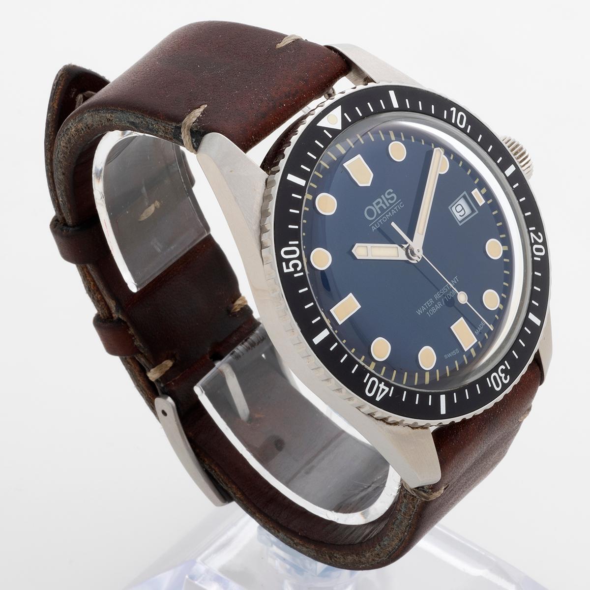 Our Oris Divers Sixty Five, reference 01 733 7720 4055, features a 42mm stainless steel case, dark blue dial and original leather strap with tang buckle. This reference is discontinued, providing a superb vintage inspired dive watch and this example