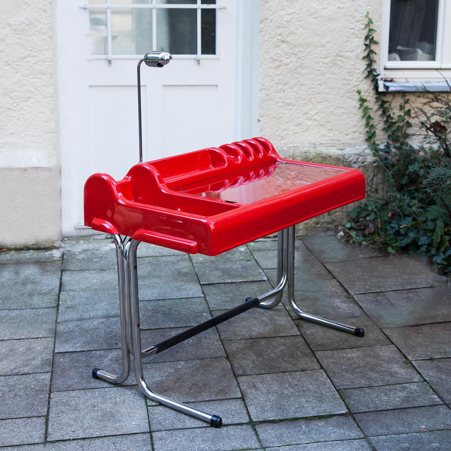 Orix writing desk produced by Molteni in the 1970s and designed by Vittorio Parigi and Nani Prina. The base is made of chromed metal and the top is made of bright red ABS. It features clear glass and a the rare desk lamp. Original manufacture label
