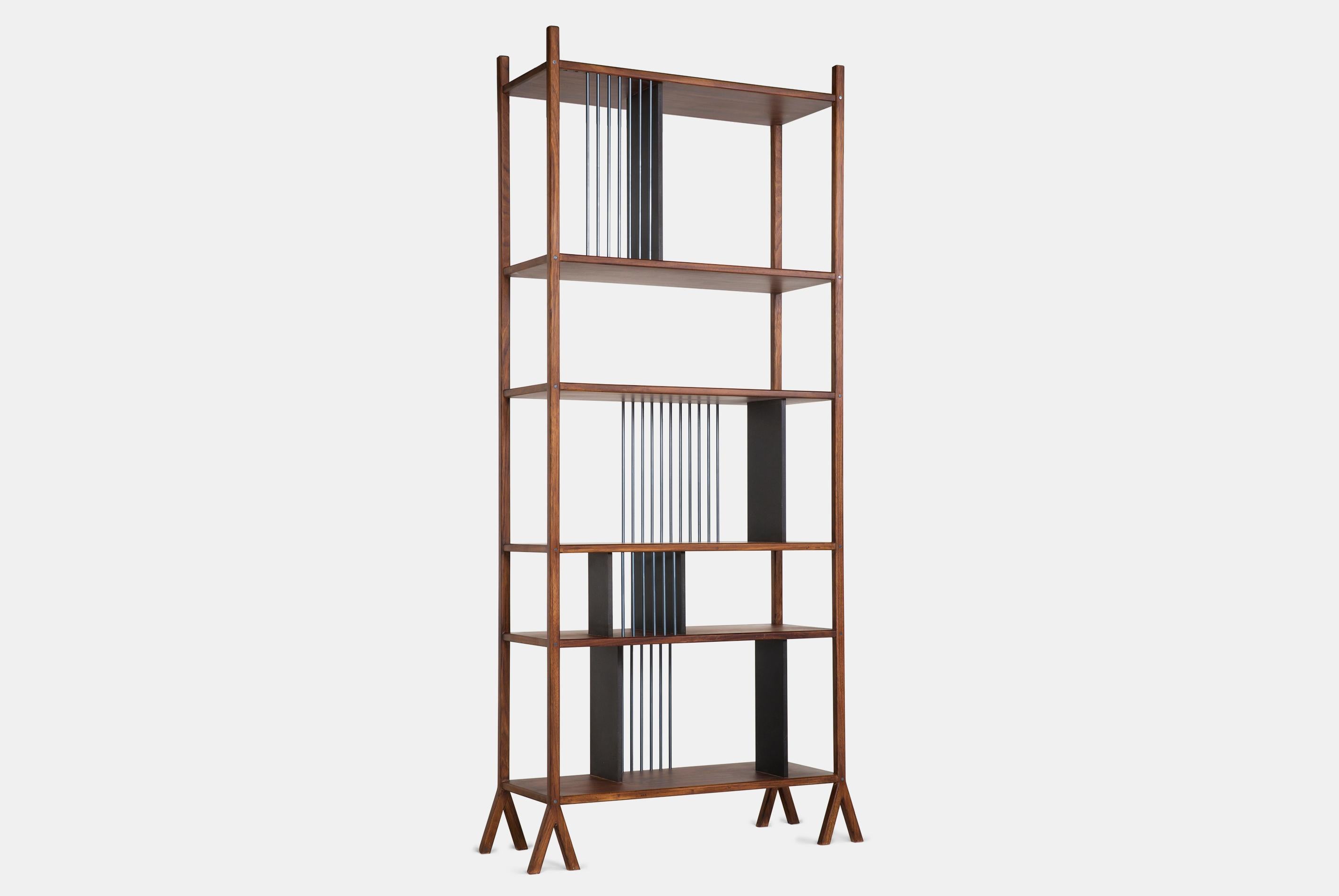 Dieses zweiseitige Bücherregal besticht durch sein schlankes Design. Dieses Bücherregal wurde als ein Verbund von modularen Teilen konzipiert, die je nach den Bedürfnissen des Kunden in verschiedenen Varianten zusammengestellt werden können. Das