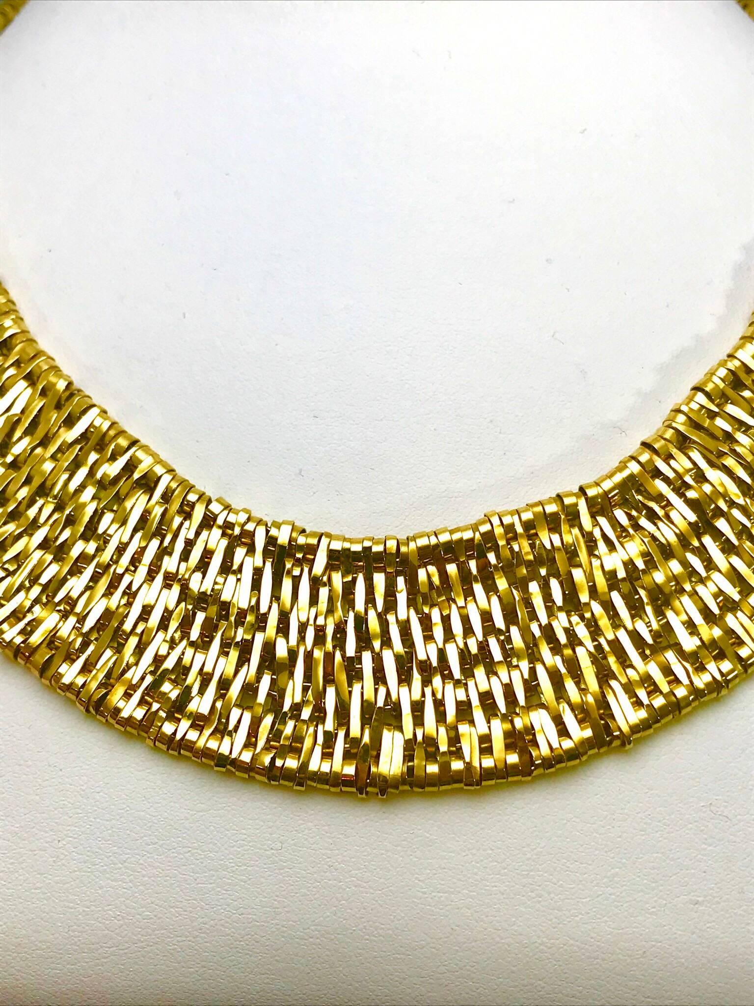 An Orlando Orlandini Fiandra wide woven link 18 karat yellow gold necklace.  The necklace is made up of small woven links, creating a very soft feel to the skin.  It has a push clasp with a safety lock.  161.43 grams.

Signature: 