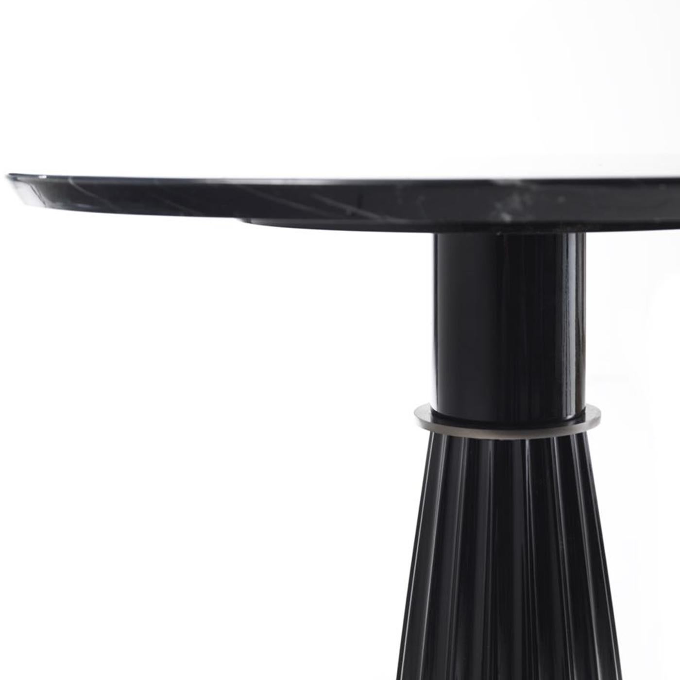 Faisant partie de la collection Orlando, cette table d'appoint haute peut être présentée seule dans un salon, une entrée ou un bureau, ou elle peut être associée à son homologue basse pour un effet dynamique. L'allure classique de cette pièce est
