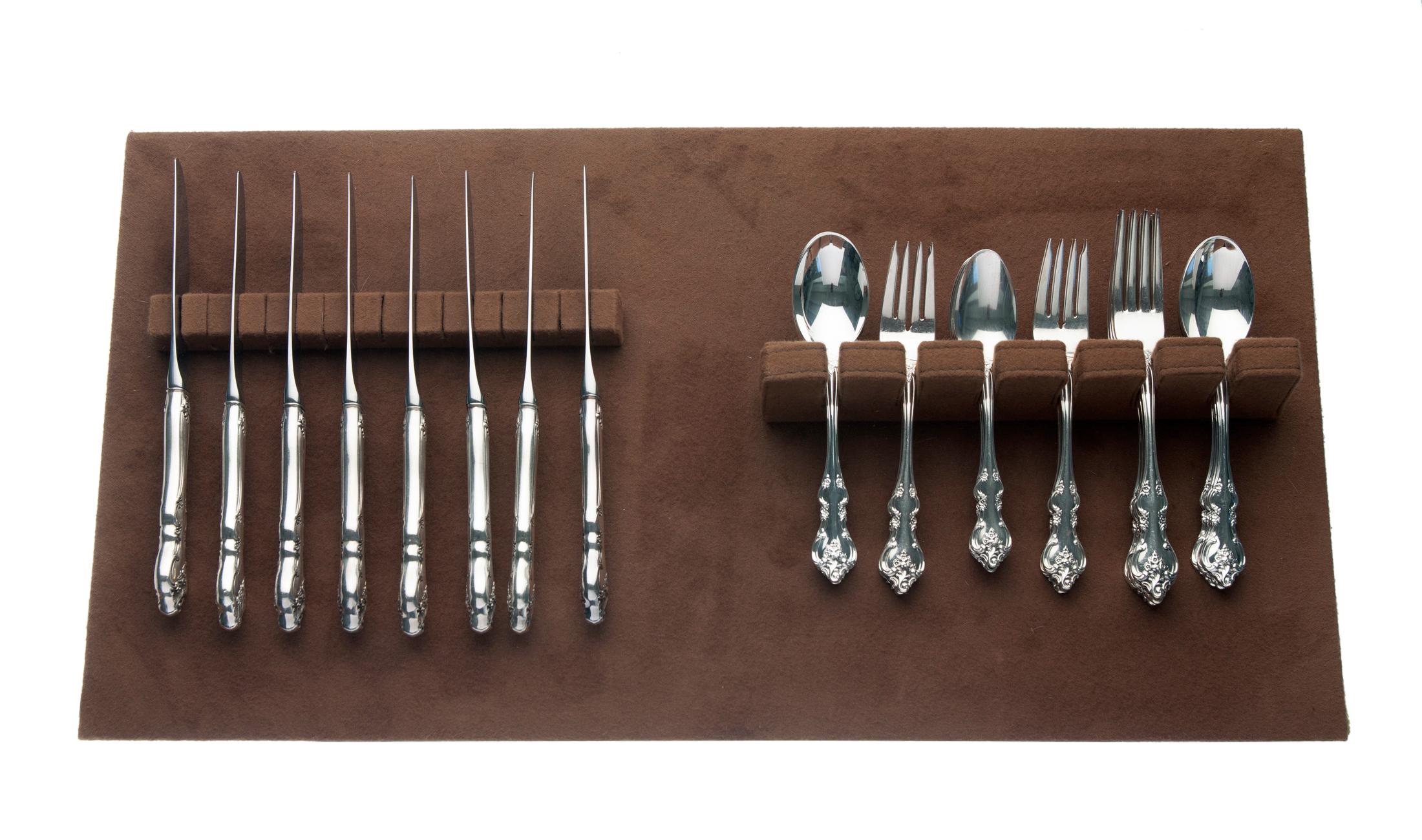 International Deep Silver Flatware in the Orleans Pattern by International Silver. The set included a drawer tray in brown felt. The set is in pristine, near perfect condition & includes;: 8 Dinner forks 8 Salad forks 8 Tablespoons 8 Teaspoons 8