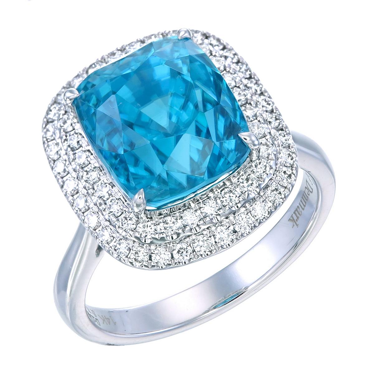 Natural Ocean Blue Zircon Cocktail Ring.
This ring features a 10.04 carat ocean blue zircon fully enveloped with a double row of SI1 diamond halos creating a classy contour brimming with charm and glamor.
14 Karat White Gold has been used to fashion
