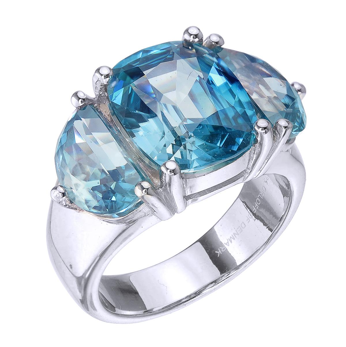 Orloff of Denmark; 925 Sterling Silver Ring set with three Natural Cambodian Blue Zircons totaling to 14.4 carats.

This piece has been meticulously hand-crafted out of 925 sterling silver.
In the center sits a fantastic 7.79 carat ocean blue zircon