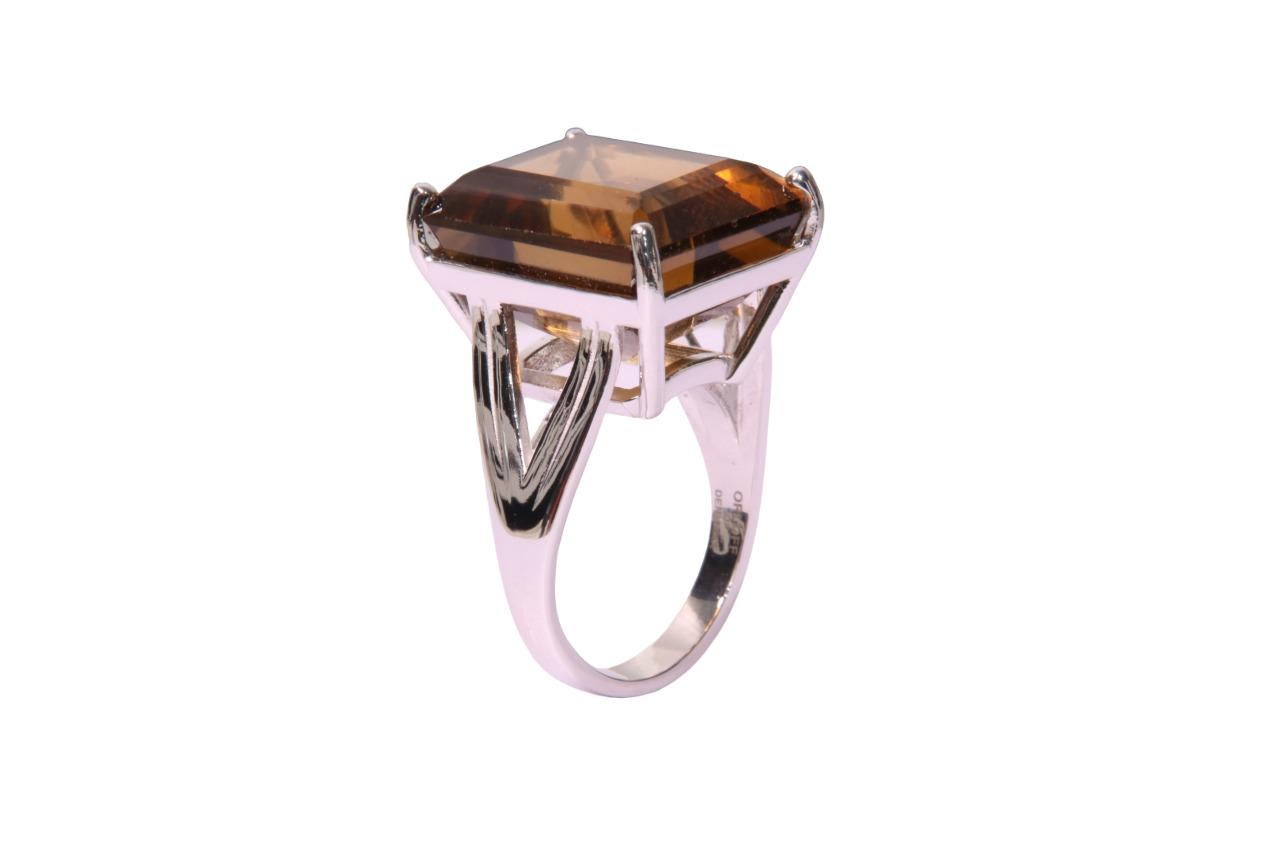 Orloff of Denmark; Dark Citrine Ring Fashioned out of 925 Sterling Silver.

This exquisite ring showcases a magnificent 22-carat dark citrine, its deep amber color exuding warmth and luxury. Cradled in a sterling silver setting, the emerald-cut