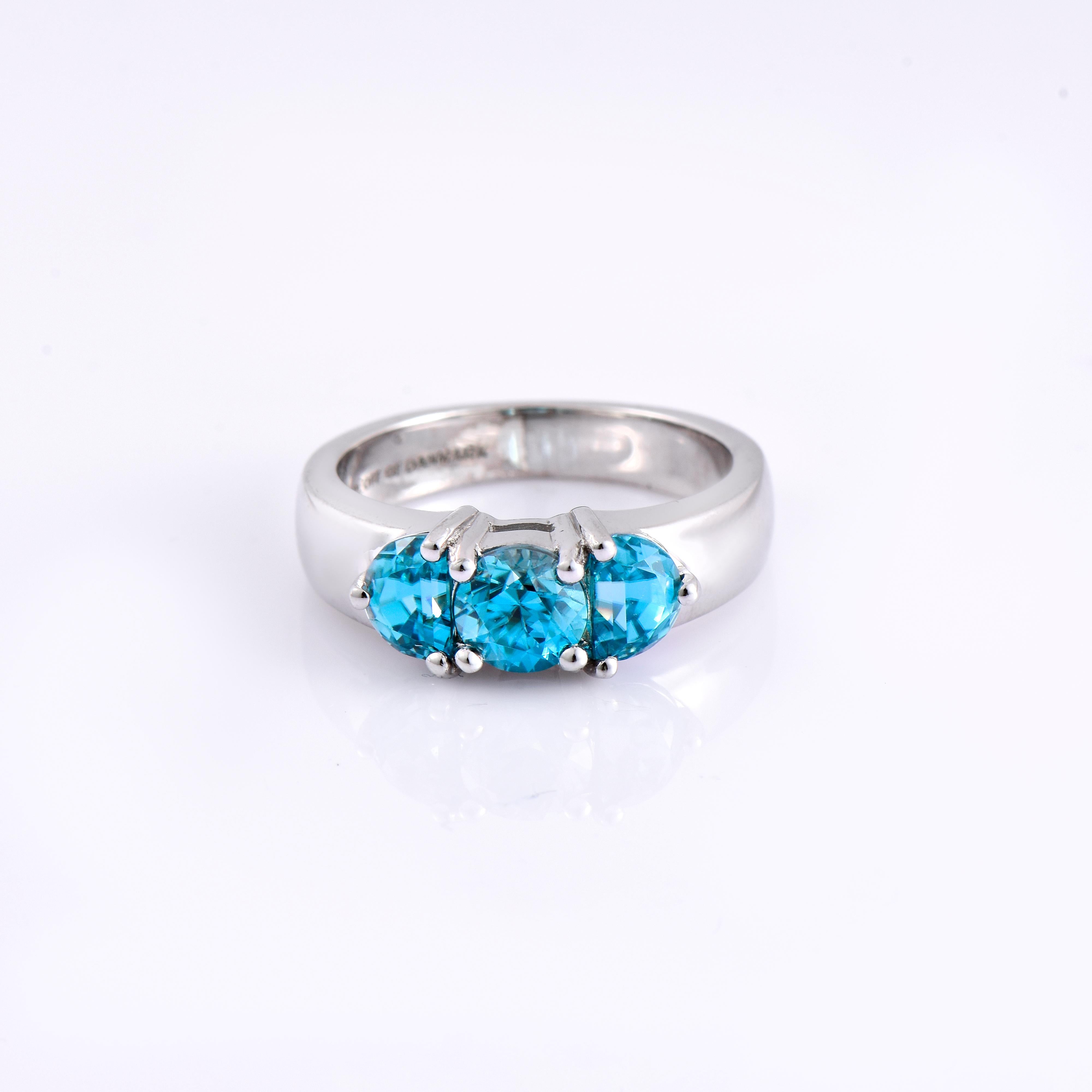 Orloff of Denmark; 925 Sterling Silver Ring set with three Natural Cambodian Blue Zircons totaling to 3.41 carats.

This piece has been meticulously hand-crafted out of 925 sterling silver.
In the center sits a fantastic 2.07 carat blue zircon