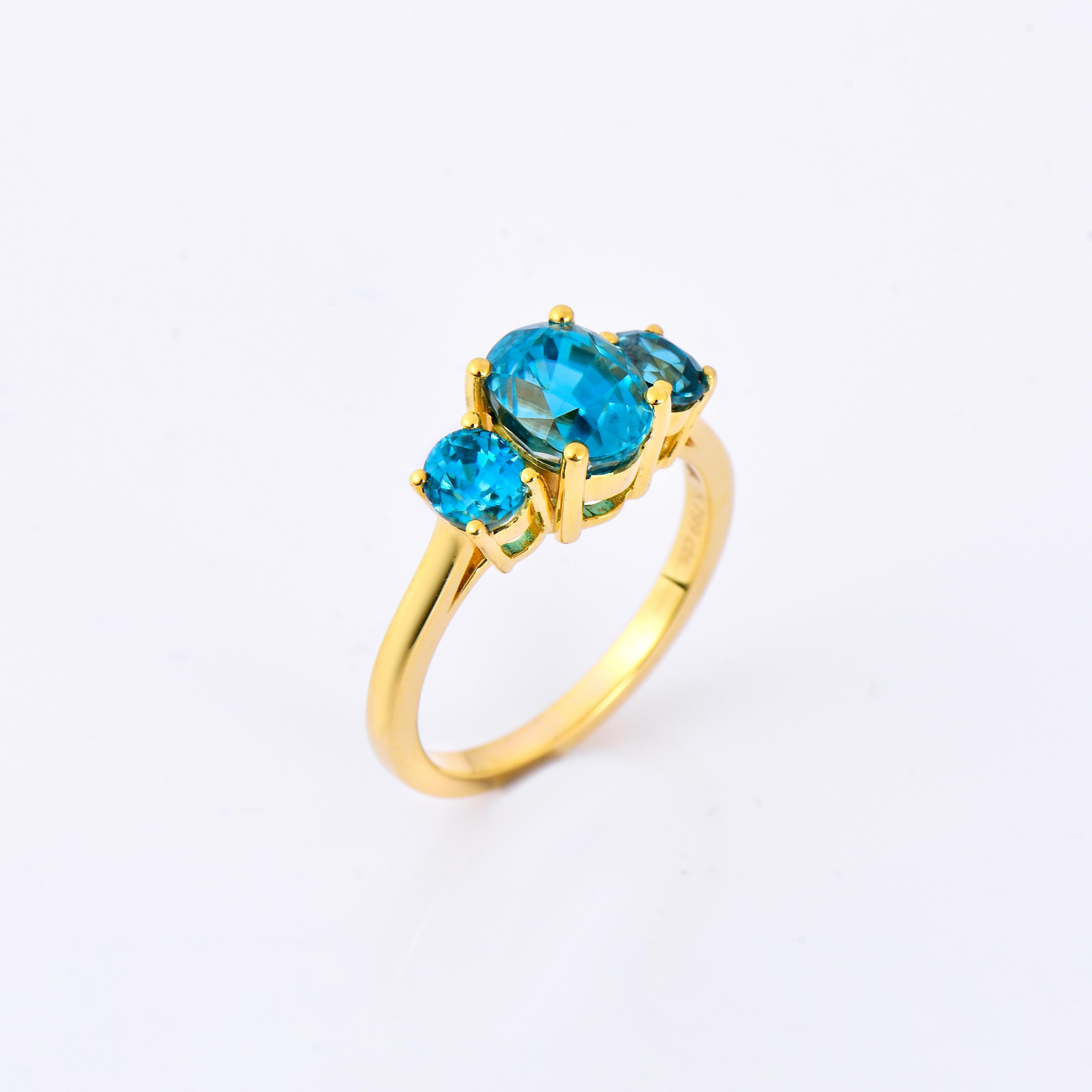 Orloff of Denmark; 10 Karat Gold Ring set with three Natural Cambodian Blue Zircons totaling to 5.8 carats.

This exquisite ring is a testament to timeless elegance, featuring a trio of mesmerizing Cambodian blue zircons set in lustrous 10 Karat