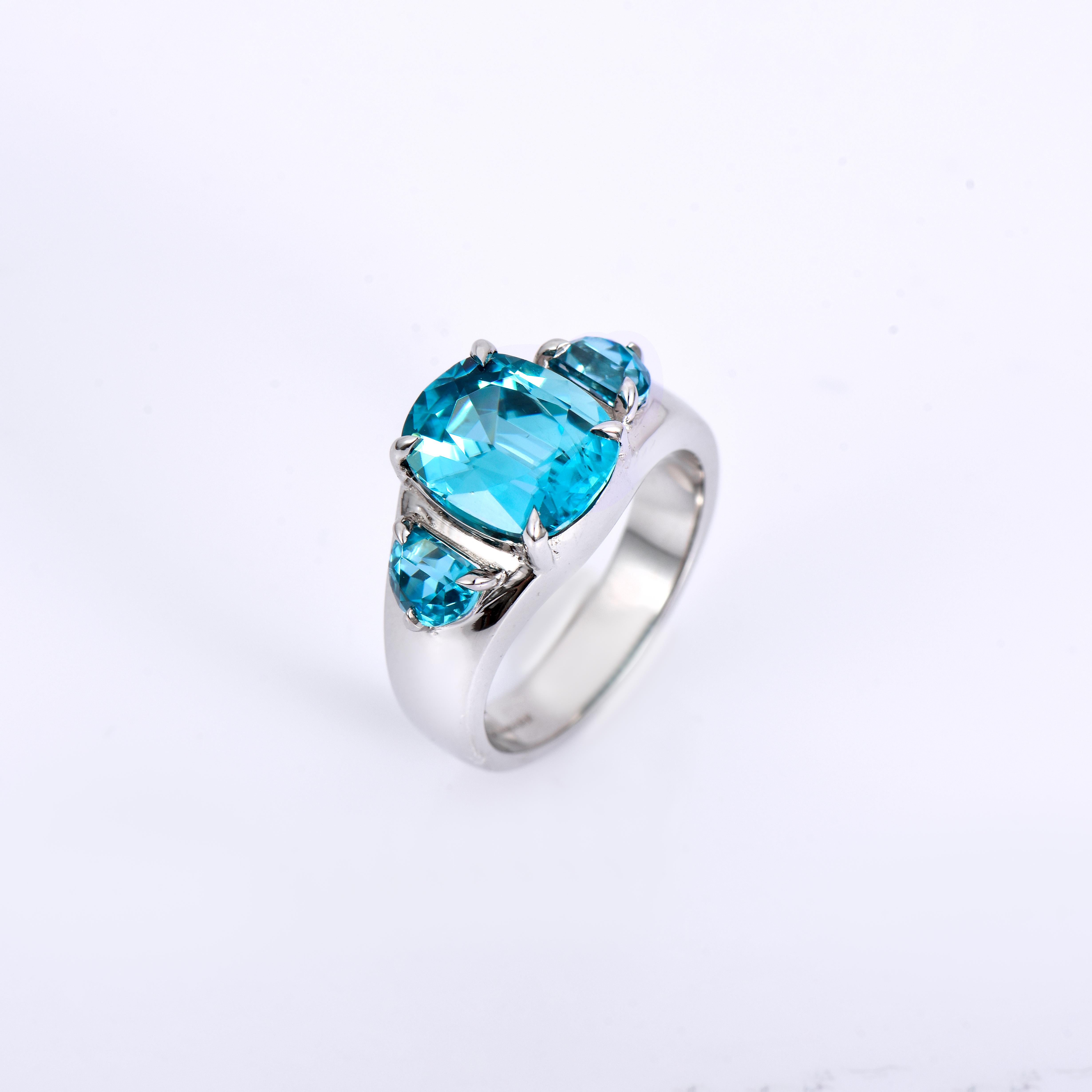 Orloff of Denmark; 925 Sterling Silver Ring set with three Natural Cambodian Blue Zircons totaling to 7.52 carats.

This handcrafted 925 sterling silver ring features a central blue zircon with two complementing half-moon side stones. The main