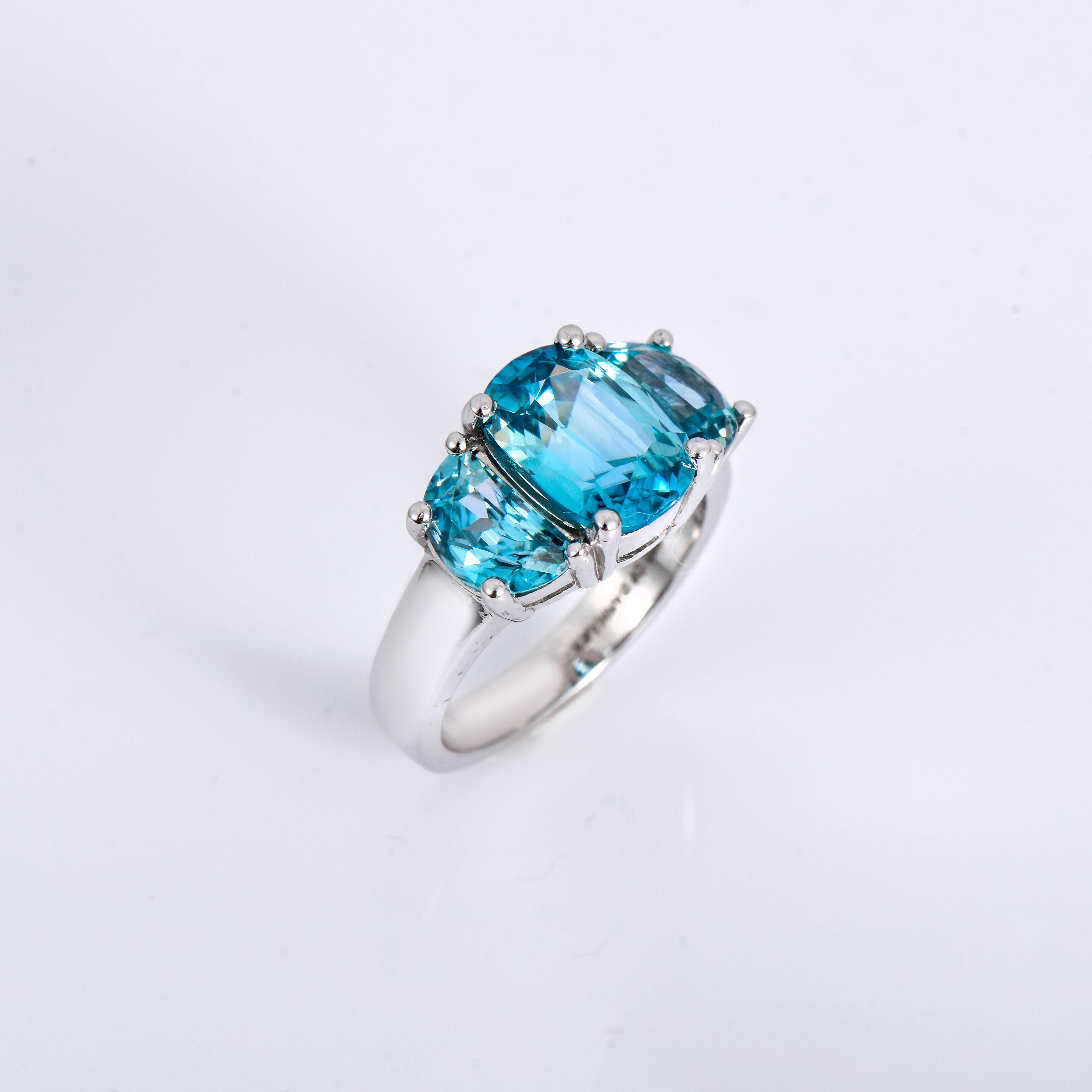 Orloff of Denmark; 925 Sterling Silver Ring set with three Natural Cambodian Blue Zircons totaling to 8.06 carats.

This 925 sterling silver ring is elegantly crafted with a central 4.68 carat cushion-cut blue zircon, complemented by two half-moon