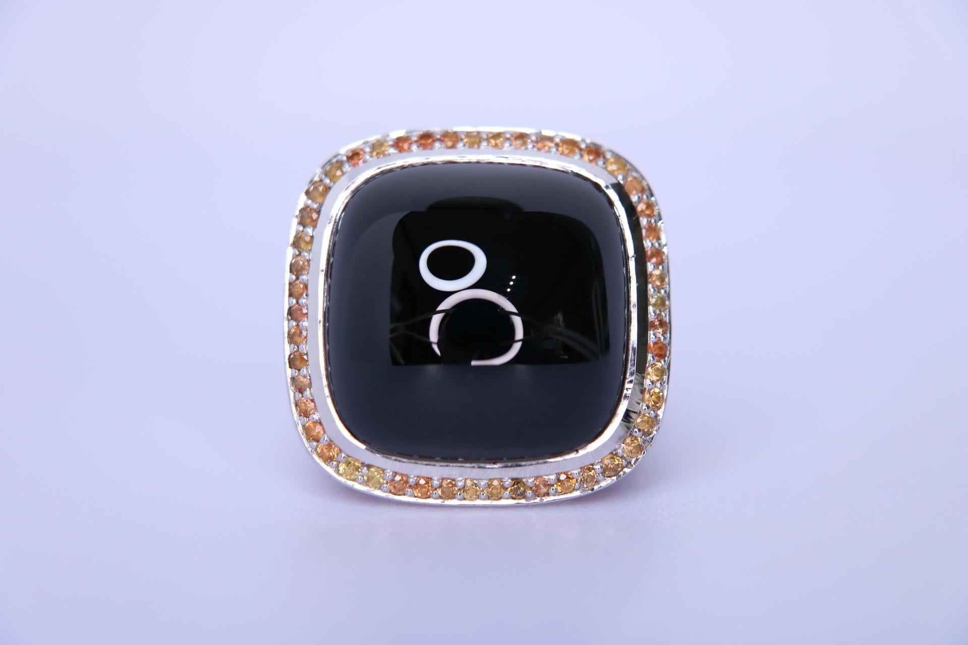 Orloff of Denmark; Statement-Ring aus Sterlingsilber mit insgesamt 0,50 Karat orangefarbenen Saphiren, die einen großen Onyx umgeben,

Dieser faszinierende Ring ist eine atemberaubende Verschmelzung von Eleganz und Raffinesse, gefertigt aus 925er