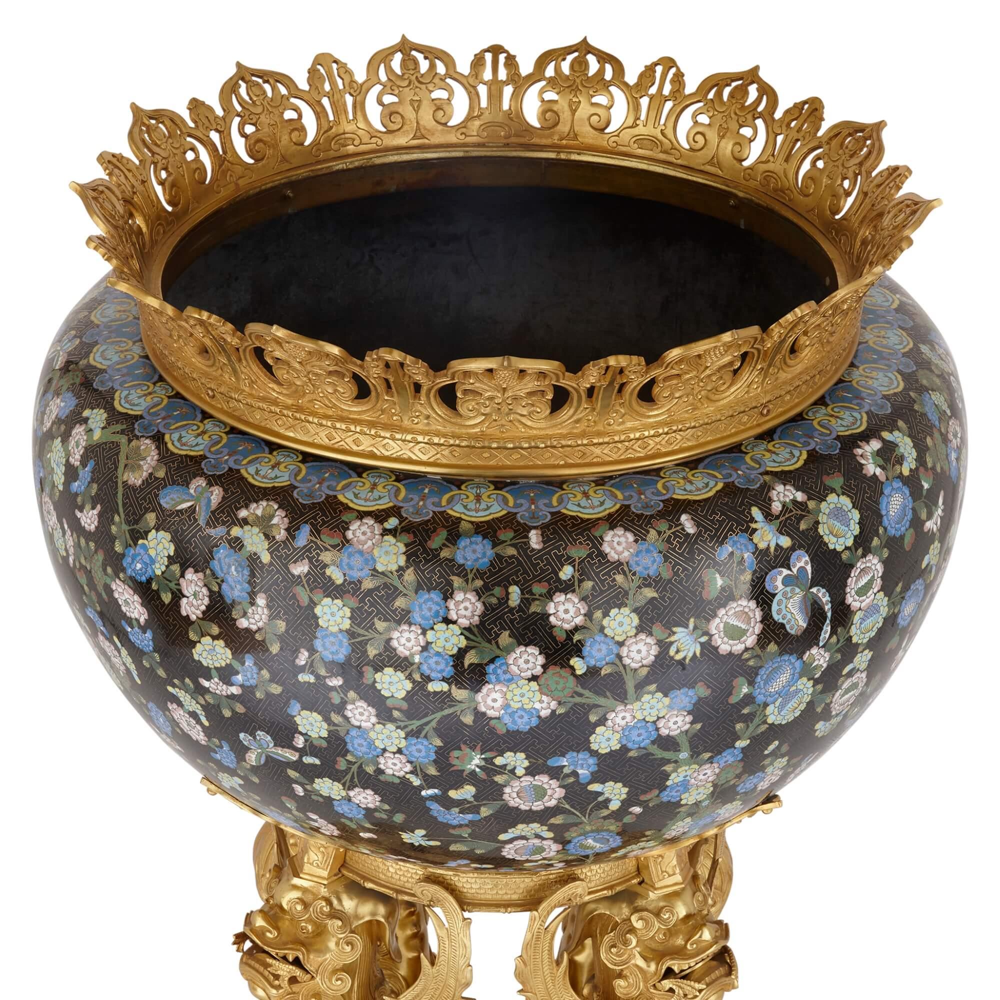 Monumentale chinesische Cloisonné-Emaille, in Ormolu gefasst, Jardiniere
Chinesisch und Französisch, Ende 19.
Höhe 105cm, Durchmesser 71cm

Bei diesem prächtigen Stück handelt es sich um eine große Cloisonné-Emaille-Jardiniere mit Ormolu-Fassung,