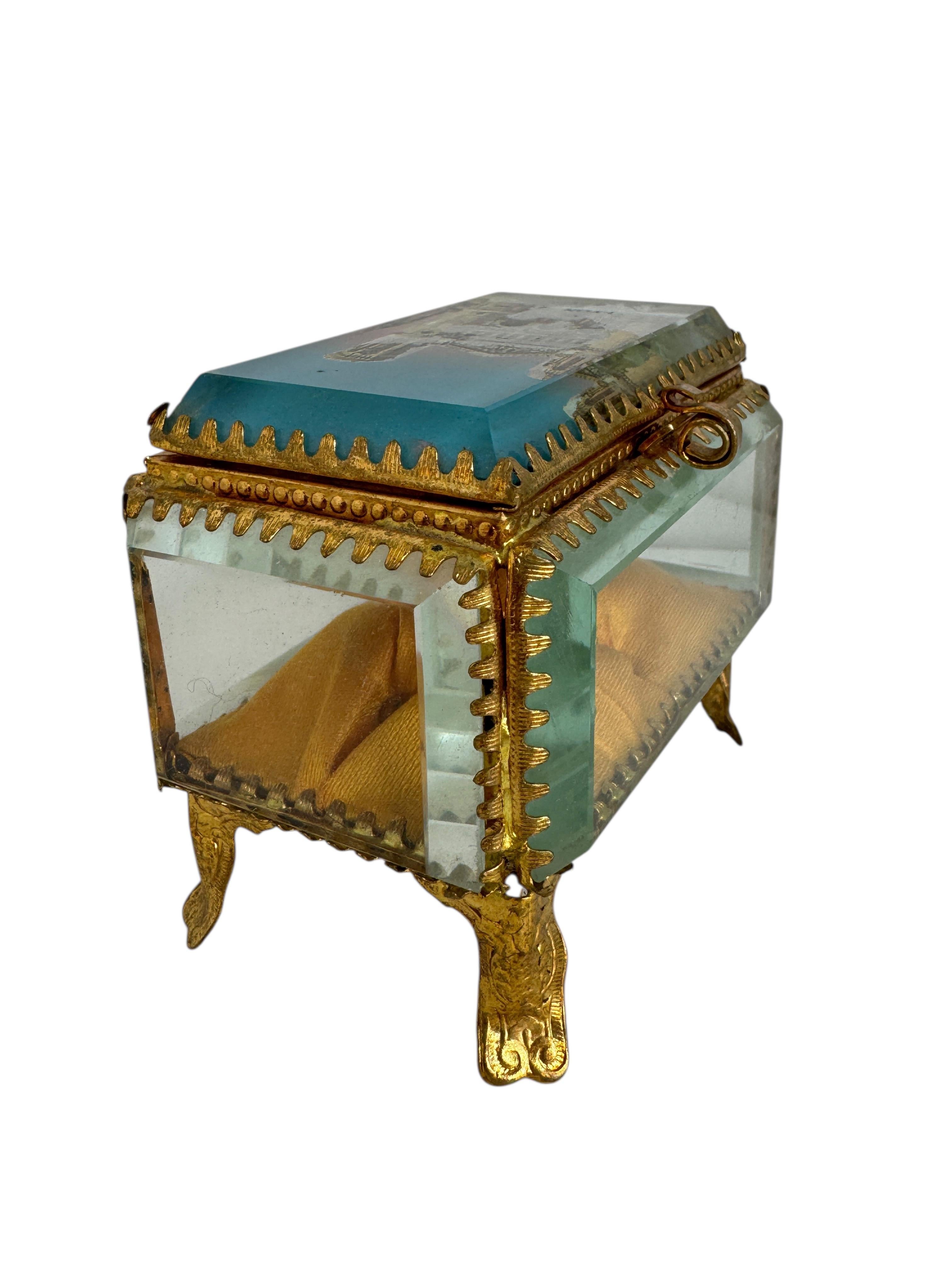 Ancien coffret d'églomisé français - Souvenir de Lyon, circa 1900

Un charmant cercueil français ancien, datant d'environ 1900, avec des ferrures en laiton doré et des panneaux en verre transparent. Le couvercle à charnière présente un verre