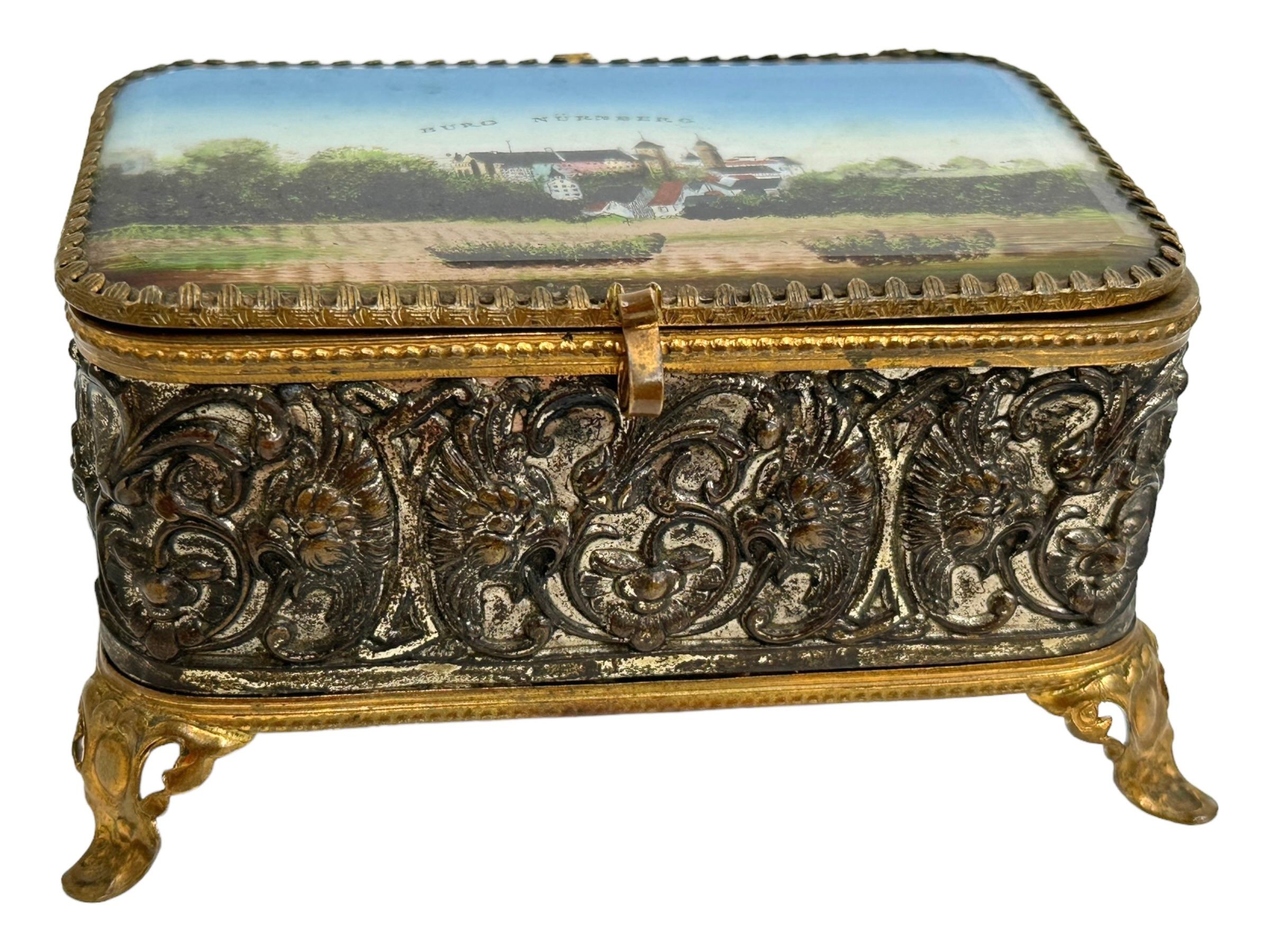 Magnifique boîte à bibelots à couvercle en verre, en bronze doré et en métal. Le couvercle à charnière présente une vue du château de Nuremberg en Allemagne. Aucune restauration n'a été effectuée sur cette charmante petite boîte à bibelots, qui