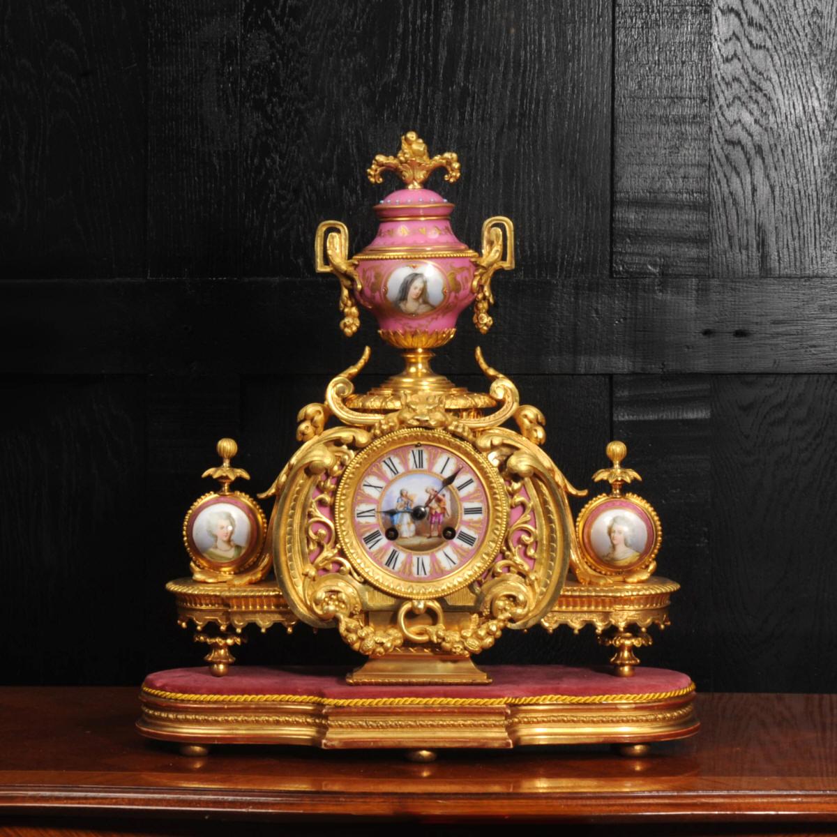 A magnificent ormolu (finely gilded bronze) and Sèvres style porcelain clock by renown maker Achille Brocot. It is mounted with delicately painted Sèvres style porcelain with a pompadour rose pink ground. The urn to the top features Marie Leczinska,