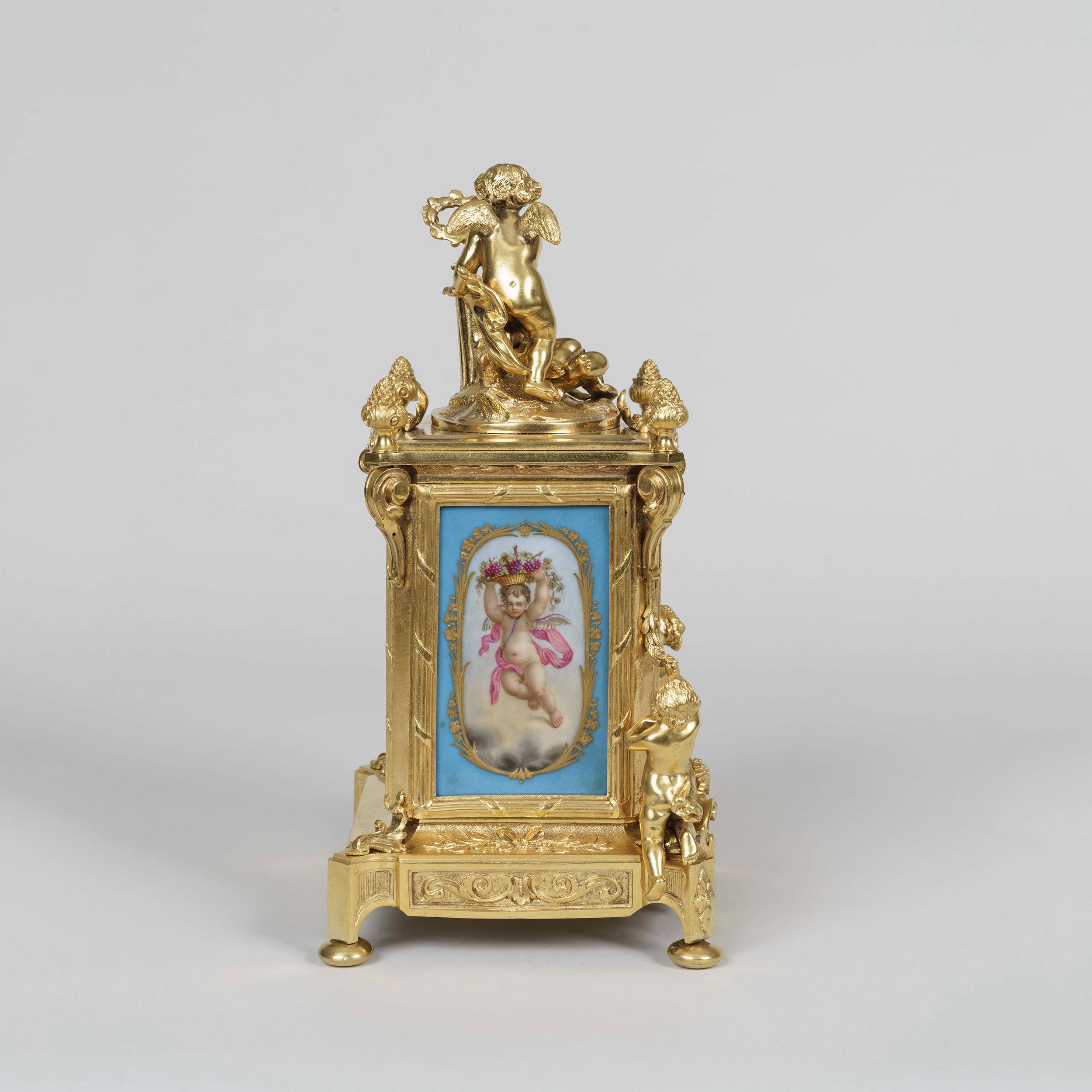 A clock garniture in the Louis XVI Manner
By Le Roy et Fils

The ormolu clock case and accompanying candelabra dressed with blue 'Sevres' style hand decorated polychrome panels to the face and sides, depicting amorini, flowers, and musical